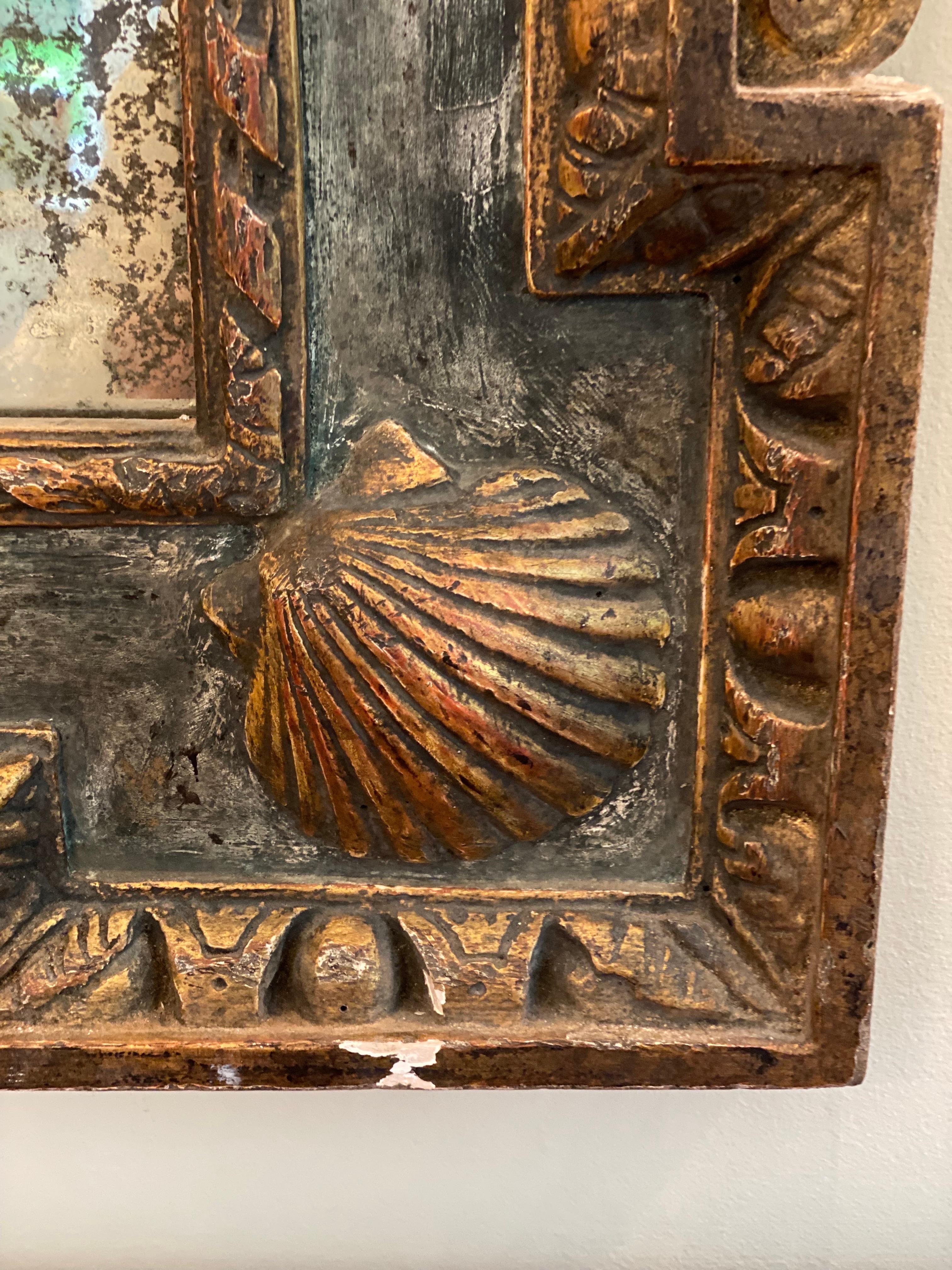 George II style painted & gilt mirror in the Manner of William Kent.
Gorgeous reproduction in a aged green painted finish with gilt embellishments on crown, shell and egg & dart motifs. Modern aged looking glass installed in segments with rosettes.