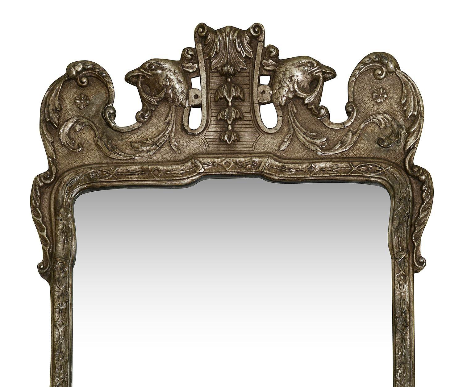 Questo squisito specchio di Giorgio II in vetro argentato e dorato, risalente al 1900 circa, mette in mostra l'eleganza del design dell'inizio del XVIII secolo. Lo specchio presenta intricati intagli, tra cui dettagliati motivi floreali e teste di