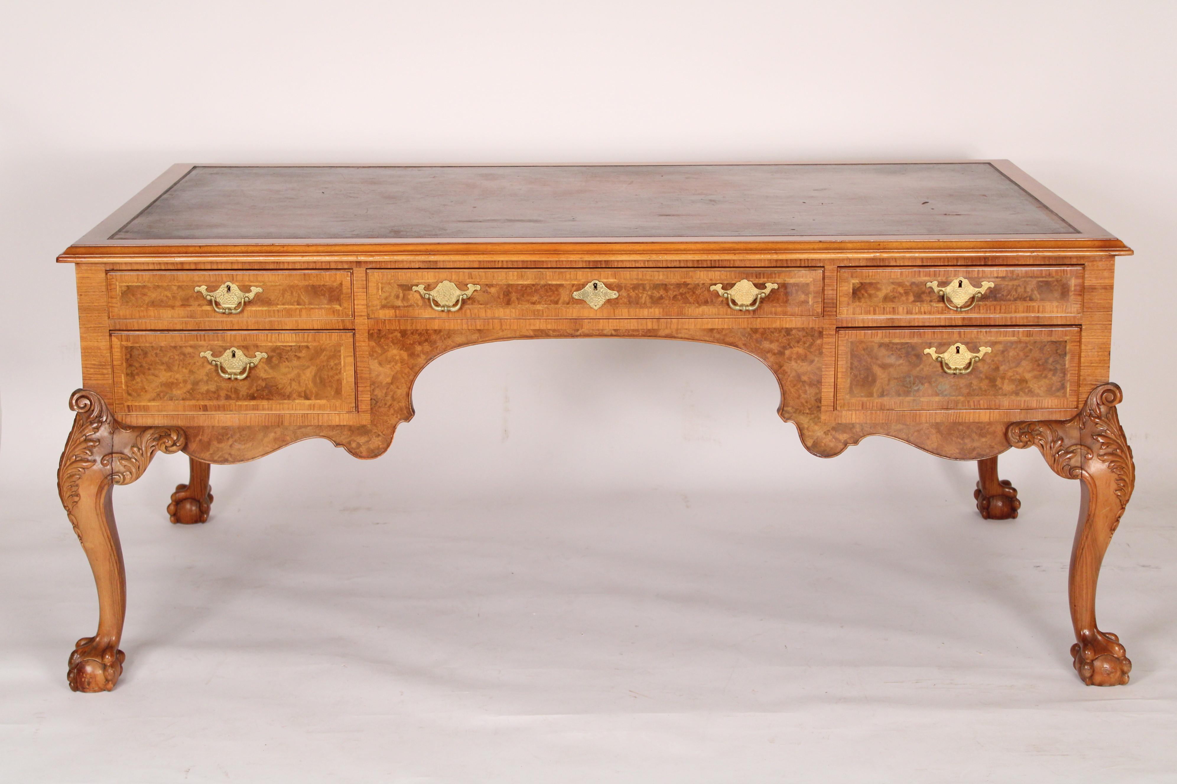 George II style walnut and burl walnut leather top partners desk, circa 1930's. With original leather top, burled walnut drawers with herringbone inlay and etched brass hardware, burled walnut sides, hand carved acanthus leaf knees and well defined