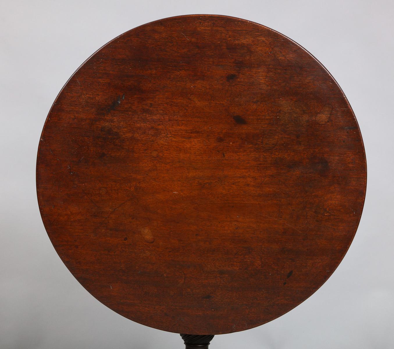 Good mid-18th century English mahogany tilt-top table with single plank circular top over balustrade turned shaft with spiral fluted urn base, the three cabriole legs ending in slipper feet, the whole possessing good rich color and patina.