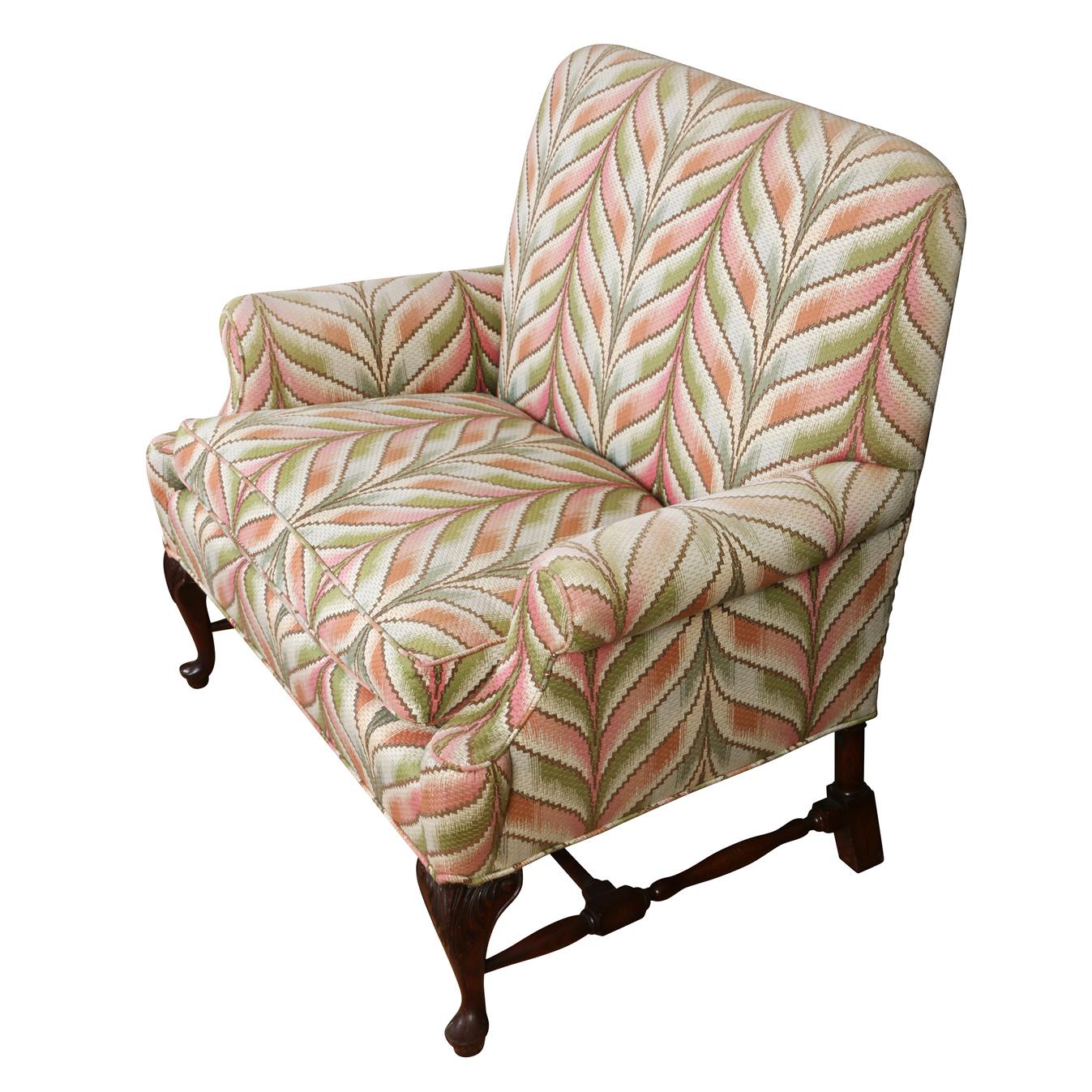 A vintage George II style settee upholstered in green and apricot ikat chevron motif with cabriole mahogany legs.