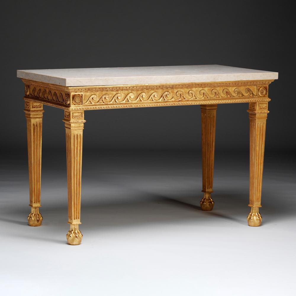 A Neoclassical gilt-wood side table with marble top above a panelled frieze decorated with a carved Vitruvian scroll. The square tapered and fluted legs are headed by paterae, carved collars, and raised on lion paw feet.

Bespoke sizing, design
