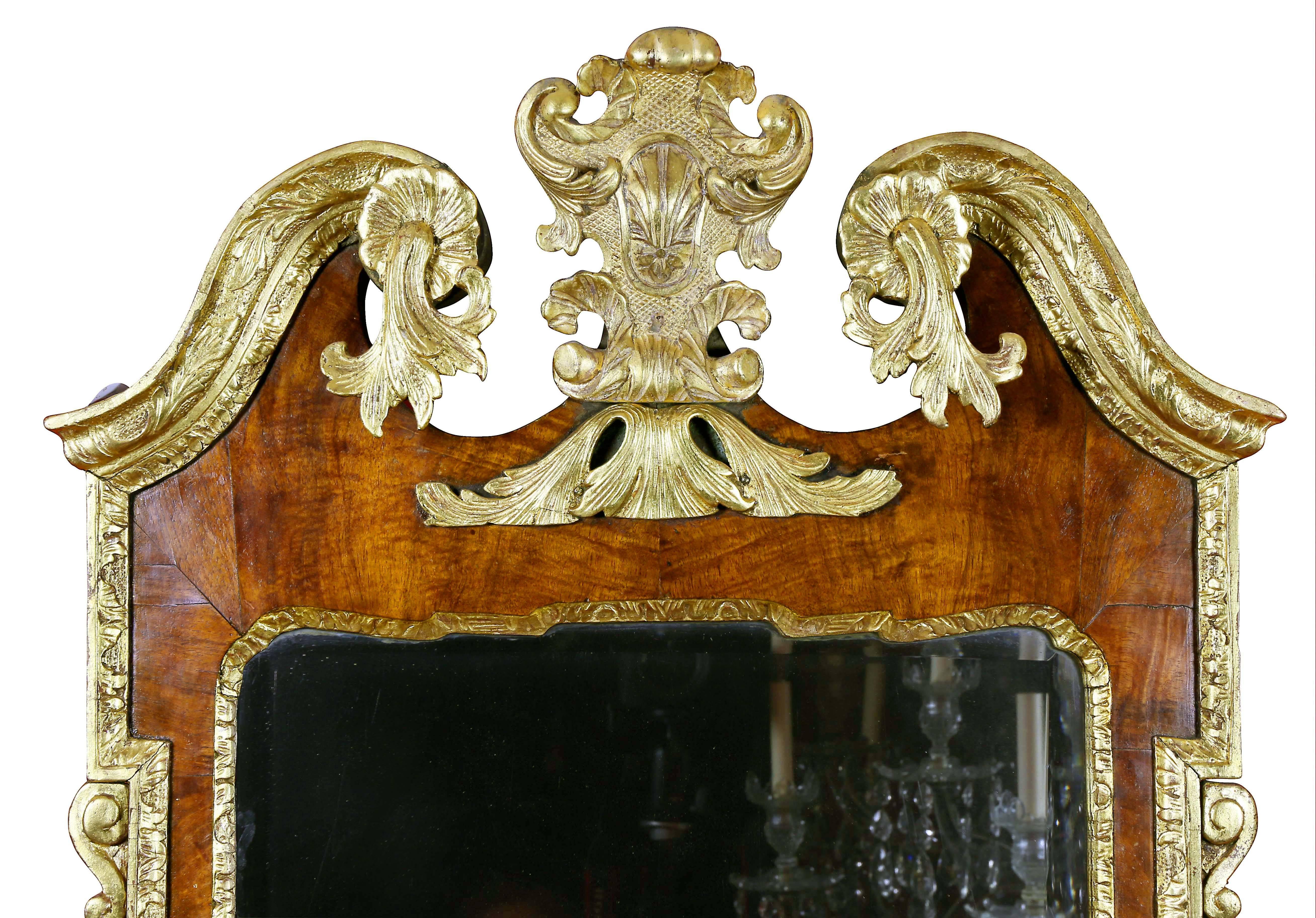 With central cartouche within a broken arch pediment above a bevelled mirror plate flanked by carved decoration, the base with shaped scrolled form.
Provenance; Stair and Co, New York.