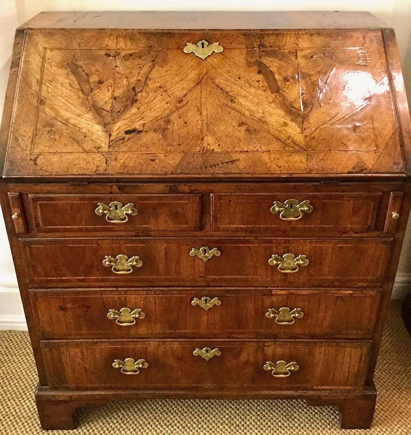 An exceptional 18th century walnut bureau with a rich color. In excellent condition and is therefore a rare find. The top falls to reveal nine pigeon-holes with four narrow paper drawers and four smaller drawers, all with brass knobs. A green beize