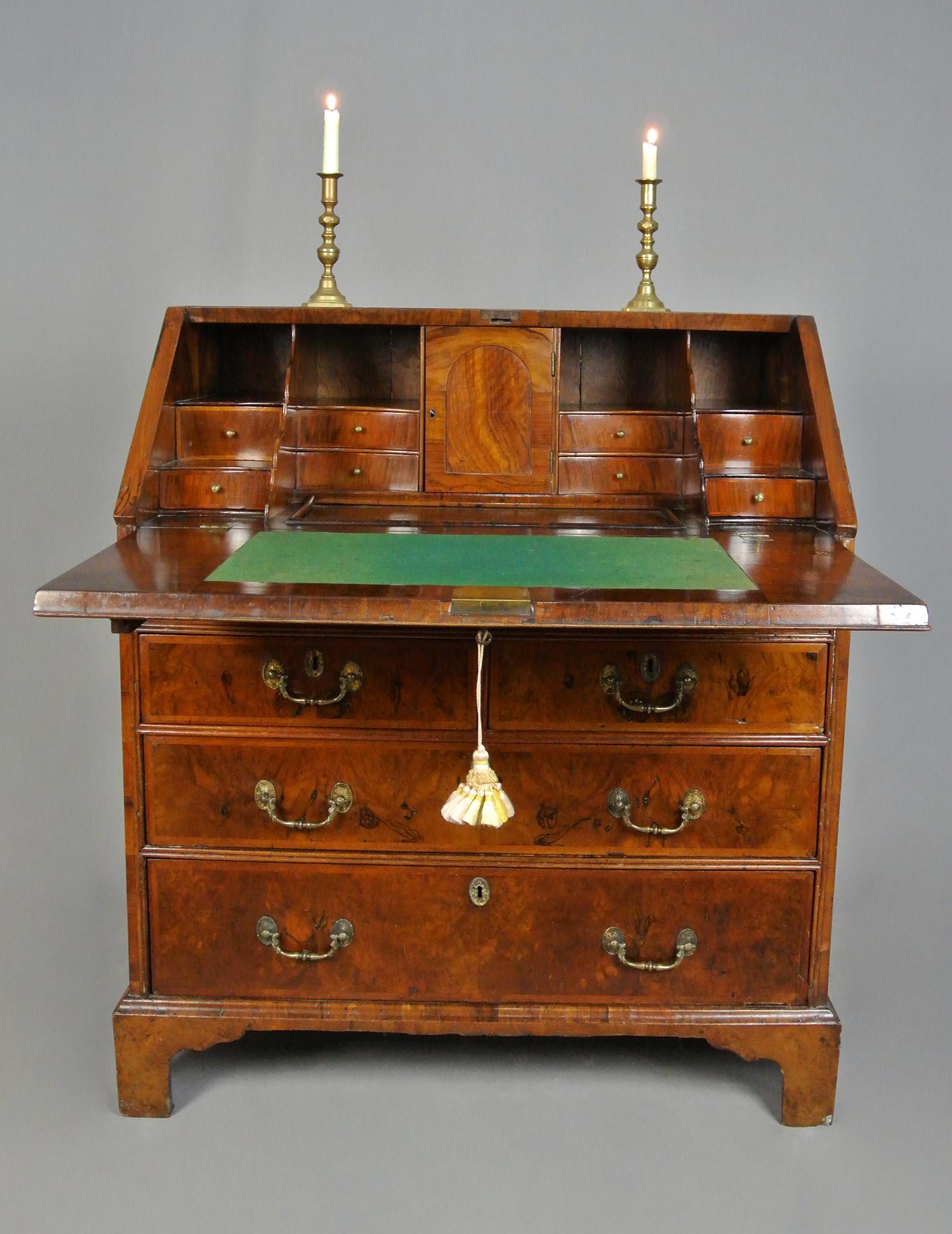Un bon bureau en noyer de George II, A.I.C., vers 1740, d'une couleur chaude et riche, en bon état, et d'une taille petite et compacte.
Magnifiques placages de ronce de noyer assortis aux façades des tiroirs, au plateau et à la façade de l'abattant,