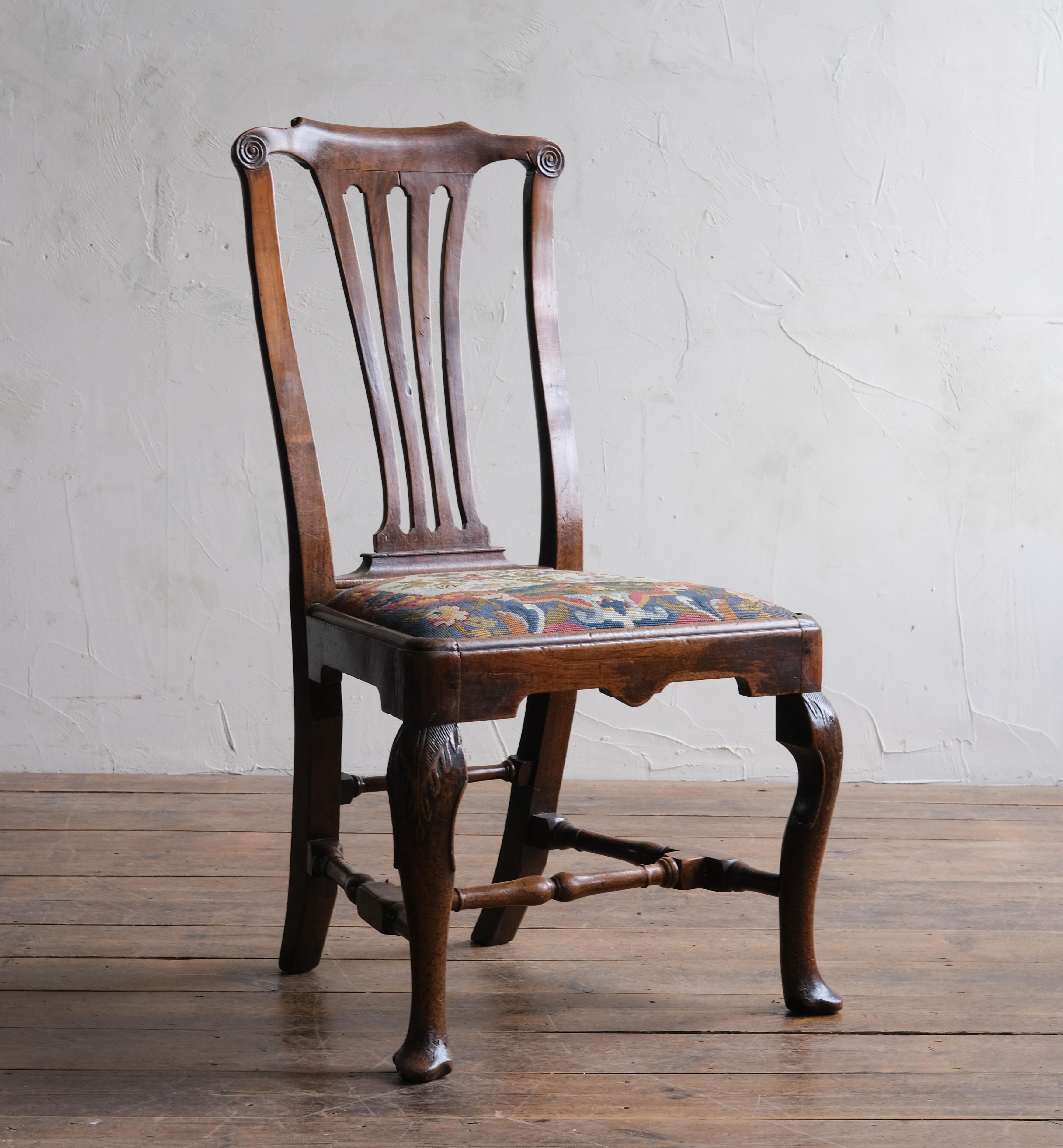 A walnut chair with carved cabriolet legs Joined with turned H stretcher and back rail, A needlework removable upholstered seat pad. Scroll top rail with pierced back splat. A nice mellow brown colour. English 1730. 

In structural sound