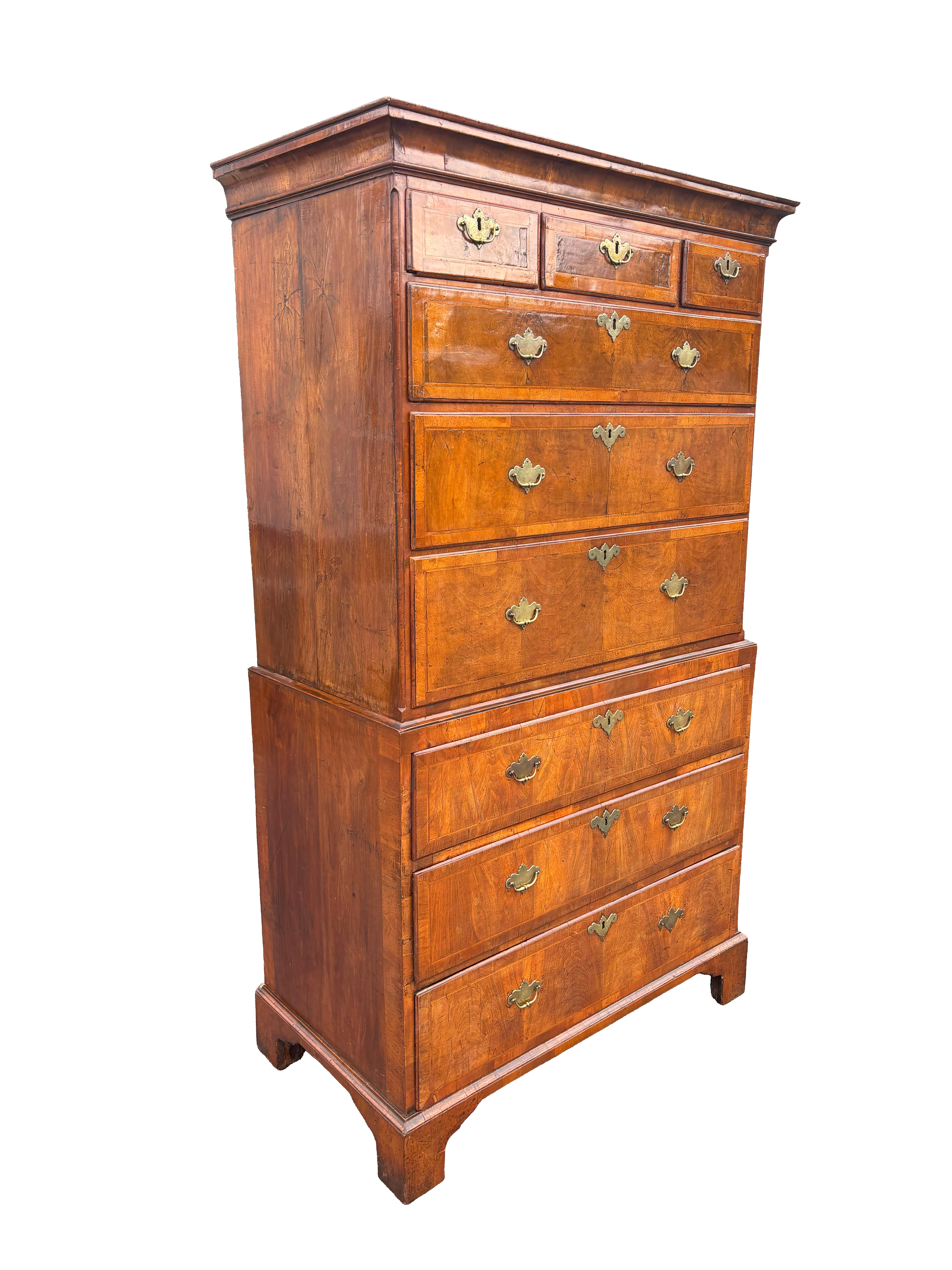 In two parts with molded cornice over three over three drawers. The base with three drawers. Bracket feet. Original handles.