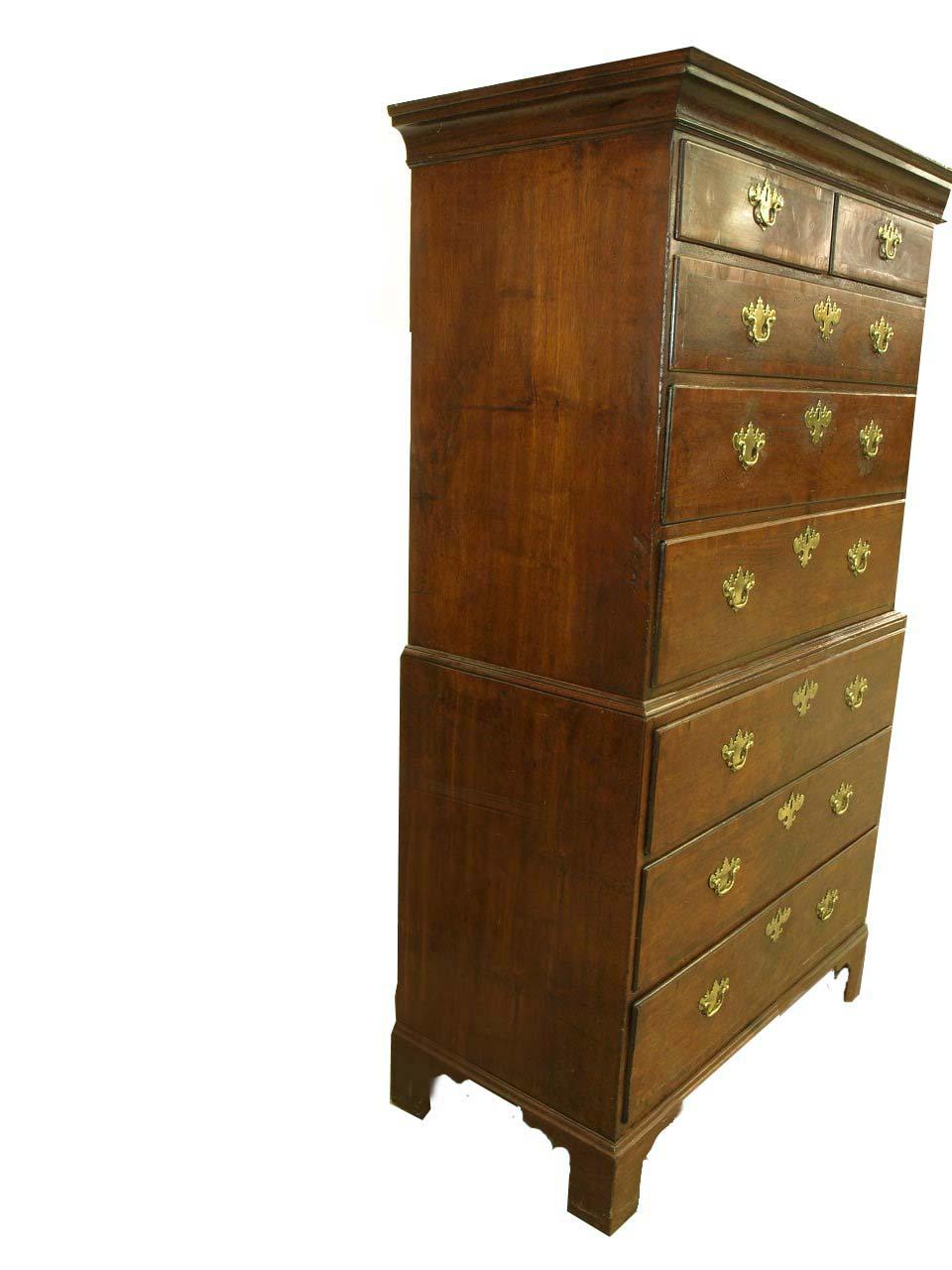 George II walnut chest on chest, the upper section with cove cornice above two over three graduated drawers, the drawers are cross banded in walnut and have oak secondary wood. The lower section with three graduated drawers, resting on bracket feet.