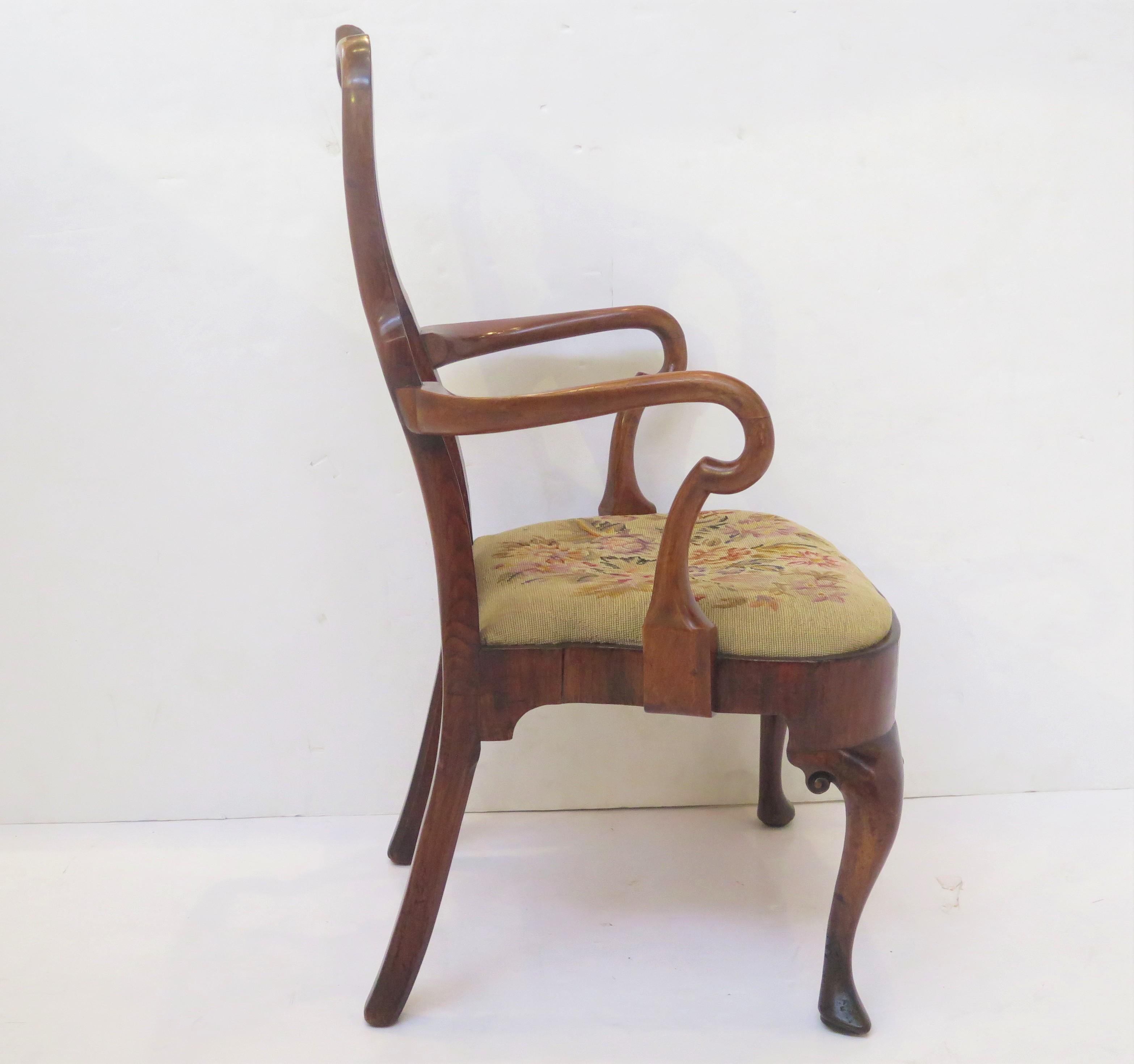 a handsome George II walnut open armchair / elbow chair, the shaped crest rail and supports centered by a vasiform splat, shepherd's crook arms, padded floral needlework slip seat above a shaped apron on tapering cabriole legs with slipper / pointed