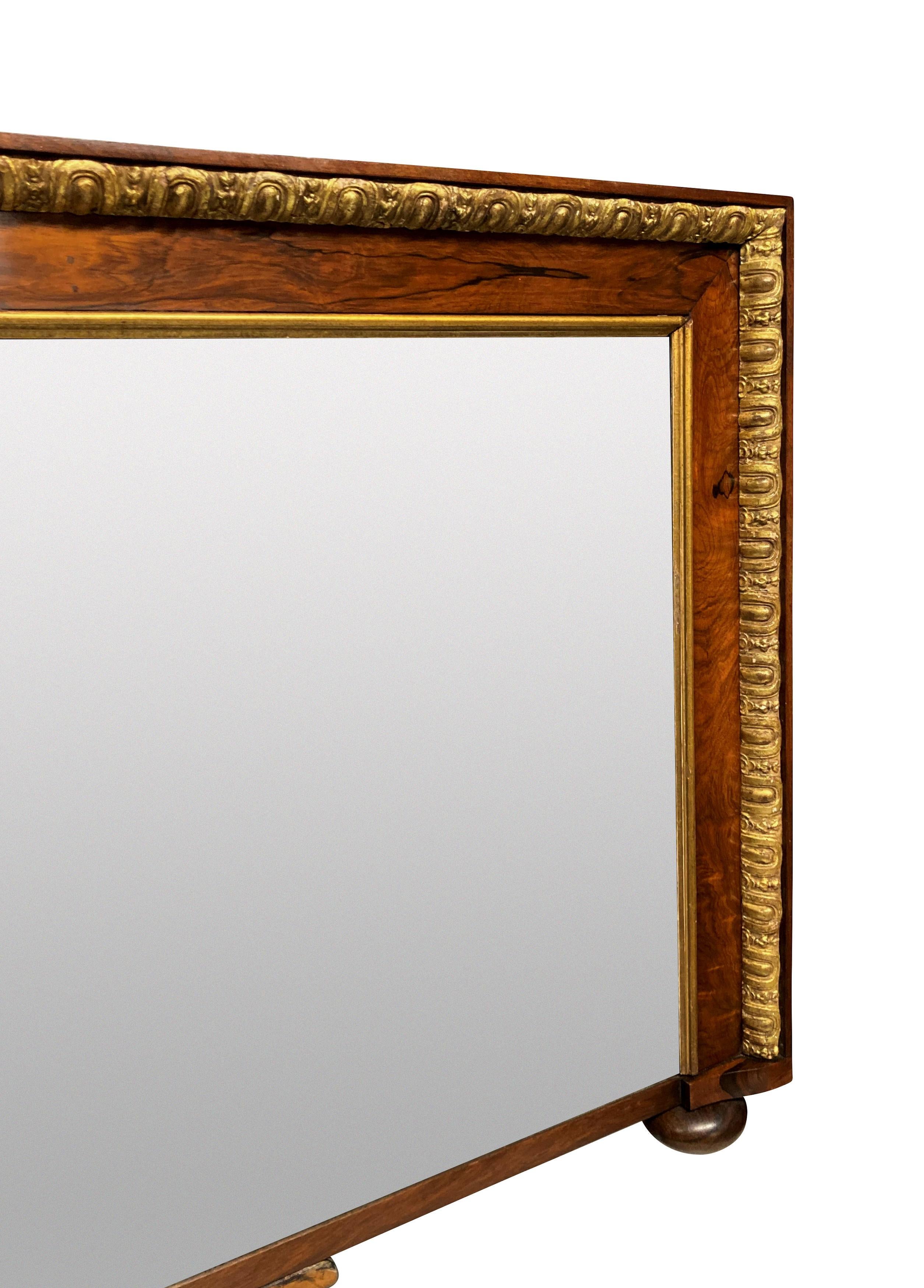 An English George II beautifully figured walnut and parcel gilt overmantle mirror, with a foxed mercury plate and on bun feet.