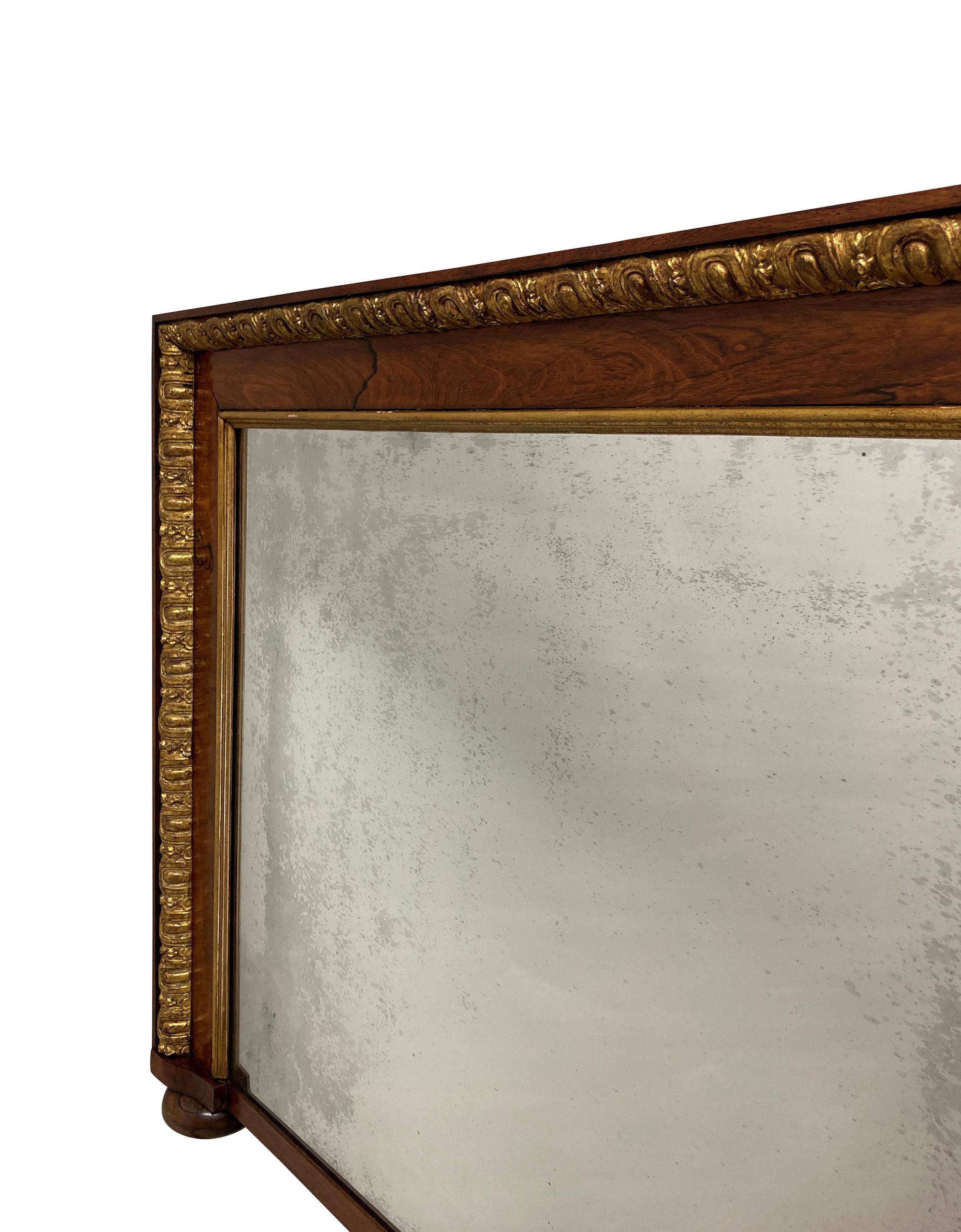 An English George II beautifully figured walnut and parcel gilt overmantle mirror, with a foxed mercury plate and on bun feet.