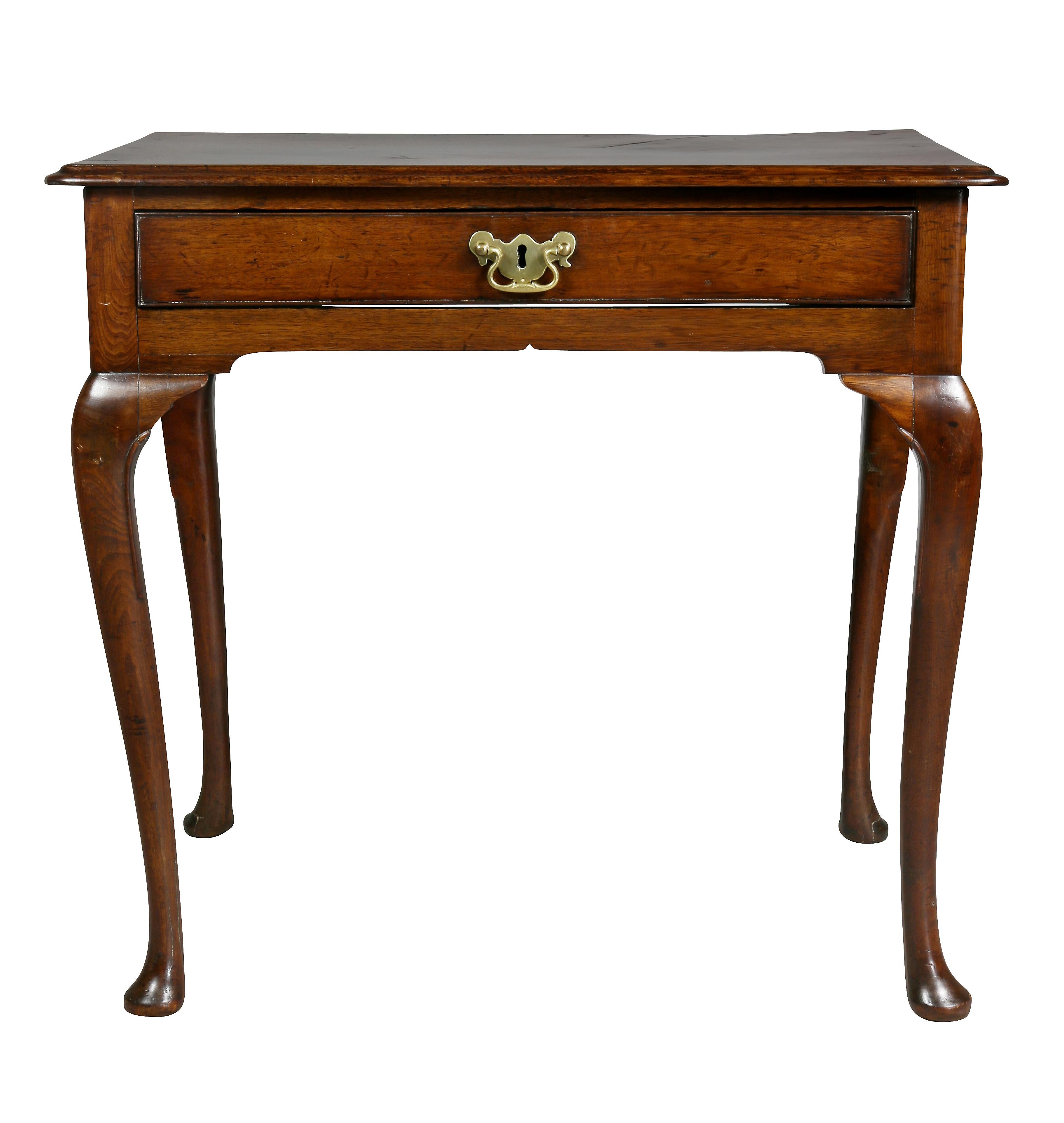 With rectangular top with rounded molded edge over a long drawer with original handle, raised on cabriole legs and ending on pad feet. Top is a solid piece of walnut.