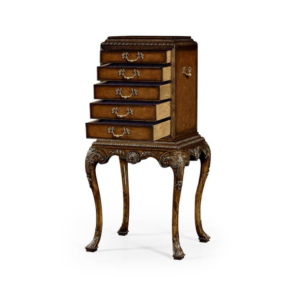 A fine George II style ornately carved walnut silverware cabinet with carved gadrooned edges, beading, graduated oak drawers with leather fronts and lined blue cloth inside, on carved cabriole legs with a central carved shell and on carved trifod