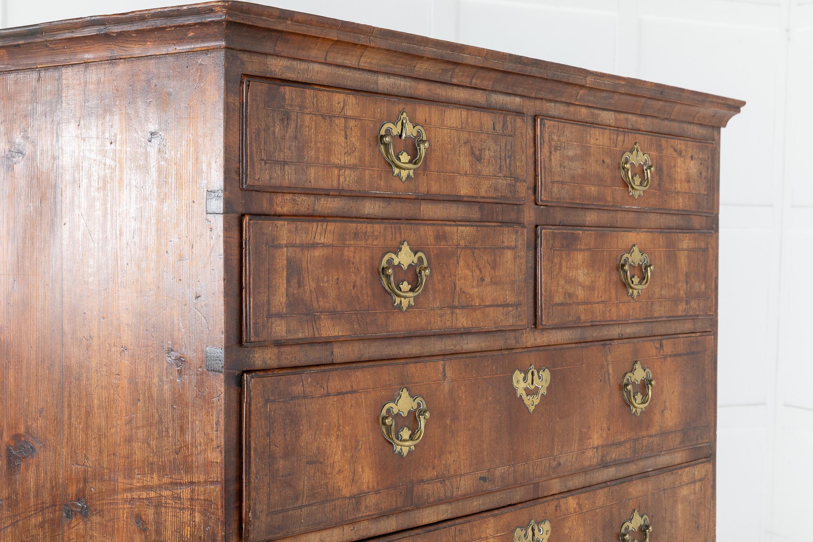 Unusual, George II figured walnut tall chest with shaped rectangular cornice at the top over four small drawers, over four graduated drawers to the bottom. It has a lovely patination, original handles and wonderful oversized bracket feet, circa 1740.