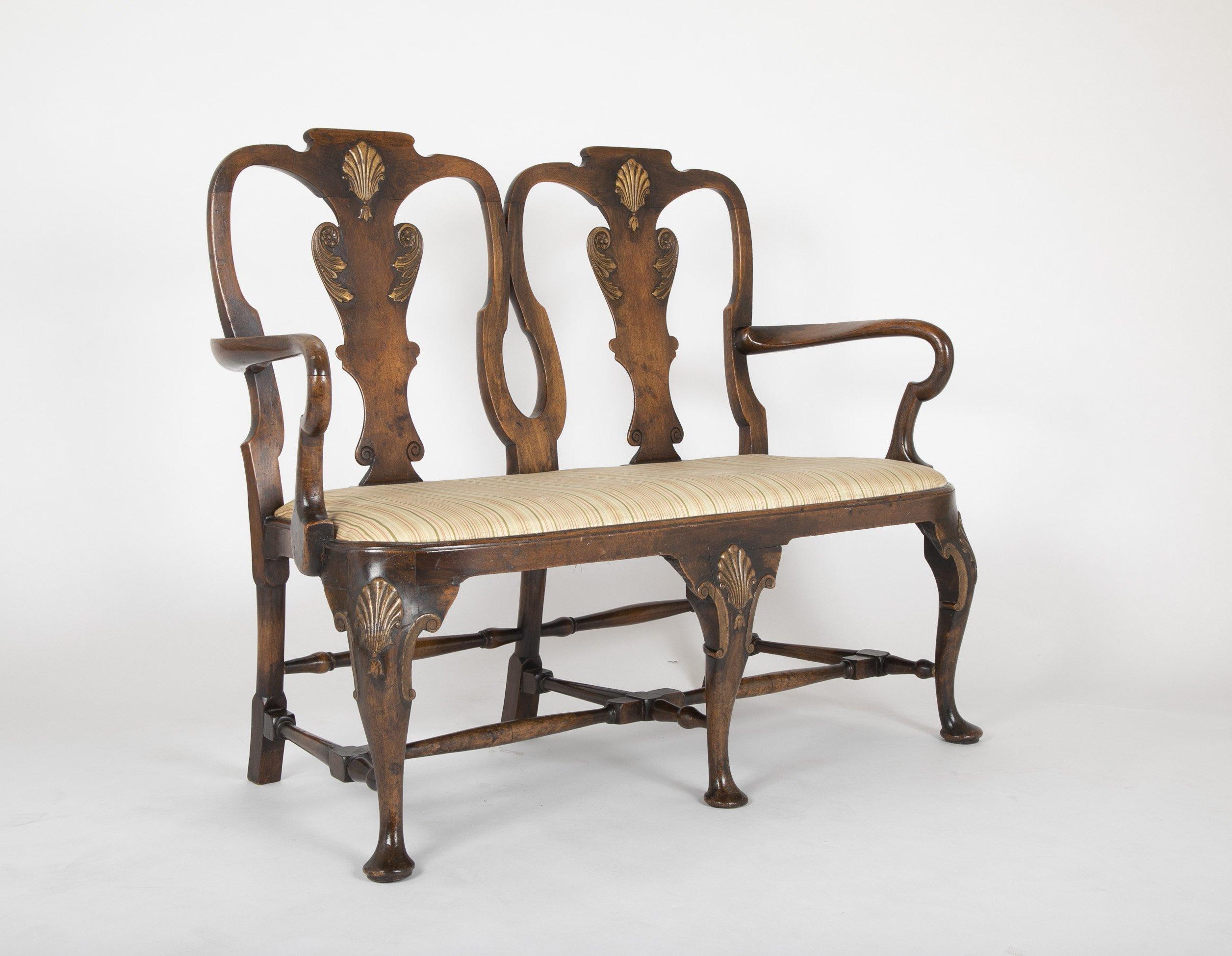 A George II walnut two chair back settee with gilt shell knees and splats, shepherds crook arms and stretcher base with the original drop-in seat of compass form. 

Early to mid-19th century.

Dimensions: 49