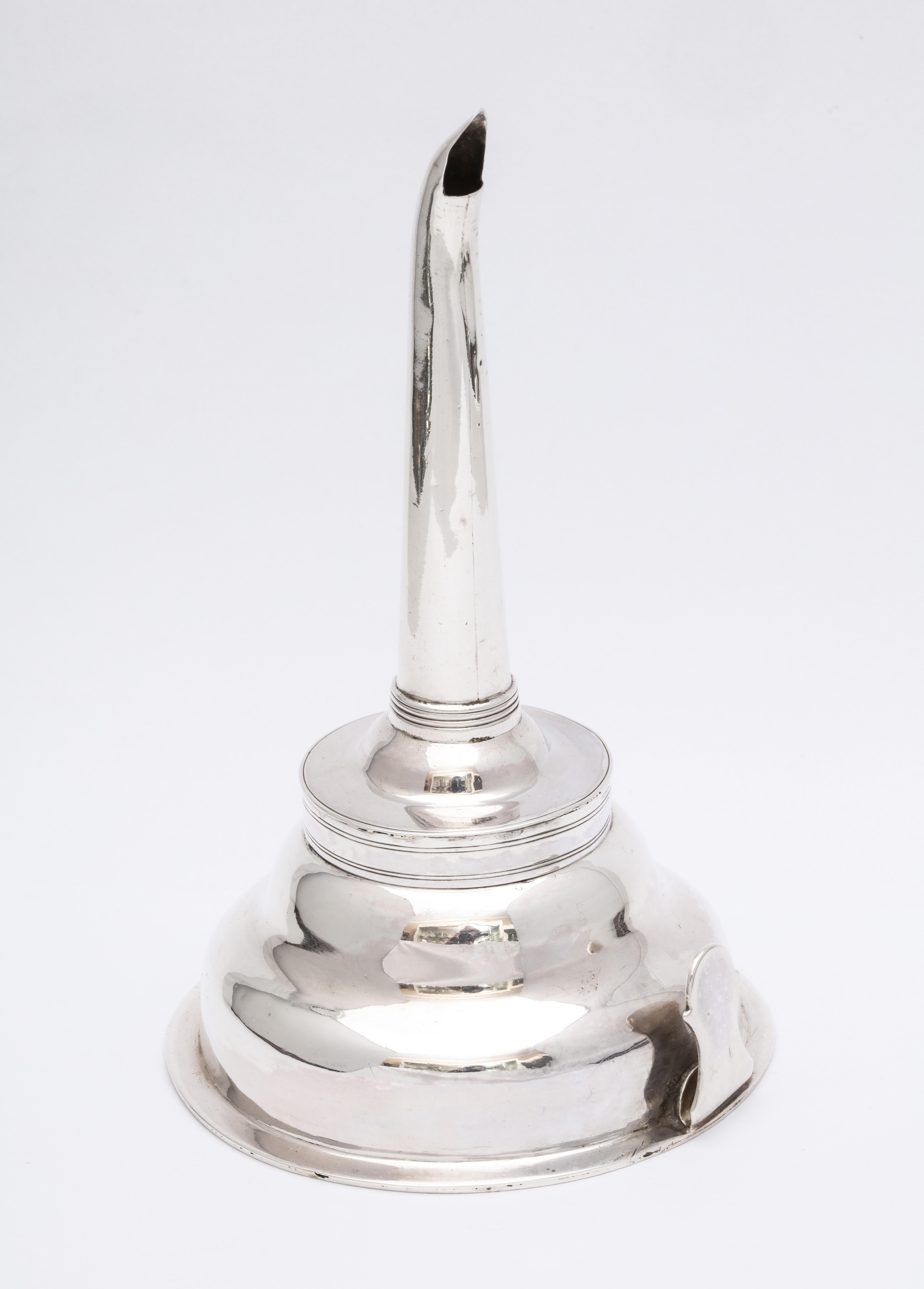 George III, sterling silver wine funnel, London, 1792, Henry Chawner - maker. Comes apart into three pieces. Ring is used to anchor a piece of linen to the funnel to aid in straining the wine. Measures 6 1/2 inches high x 3 3/4 inches in diameter.