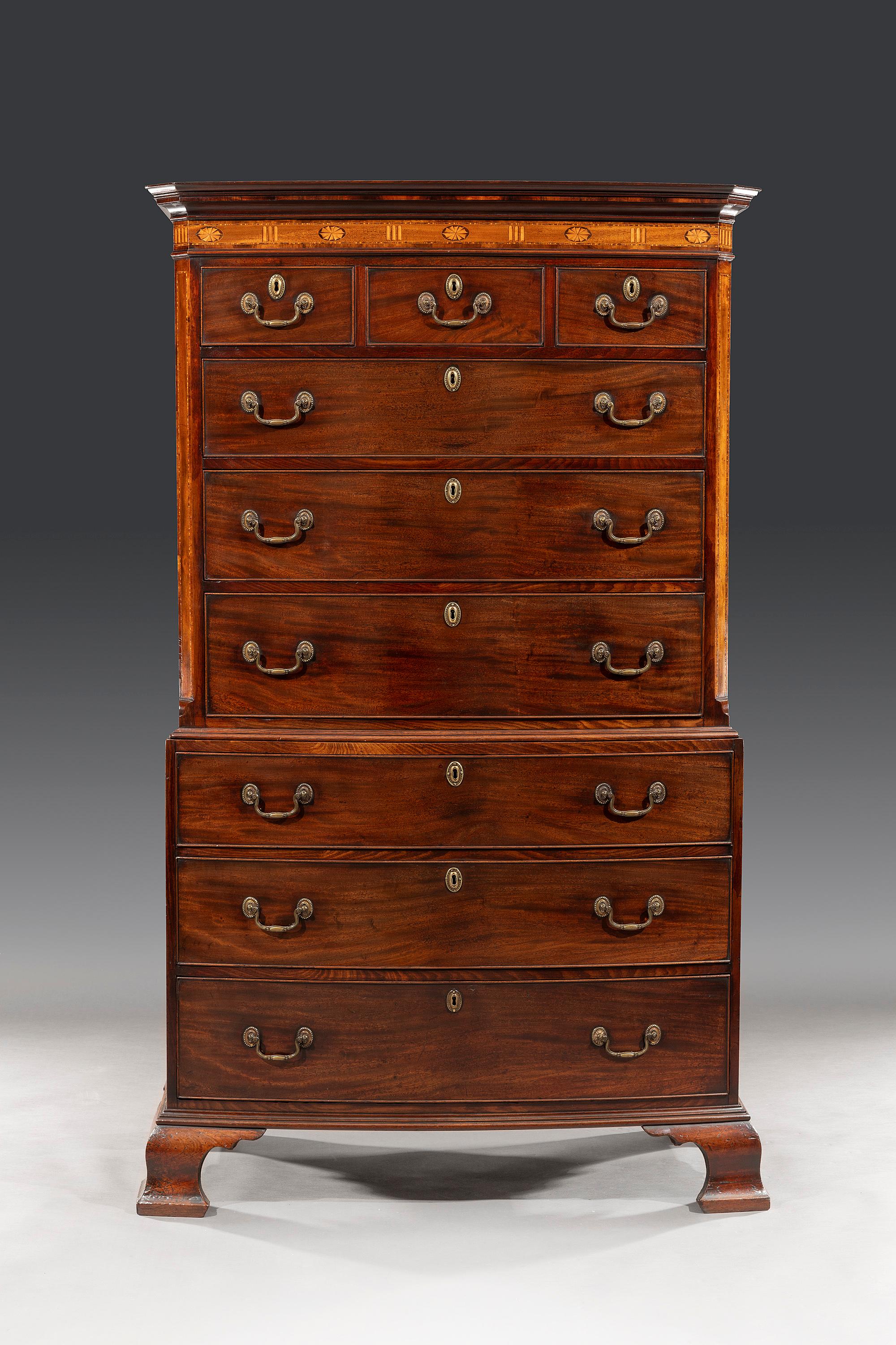 The chest on chest has a slender cornice with goncalo alves cross-banding and a bevelled moulding, above an inlaid frieze and boxwood fanned medallions, satinwood fluting and barber strung banding. The top section consists of three short and three