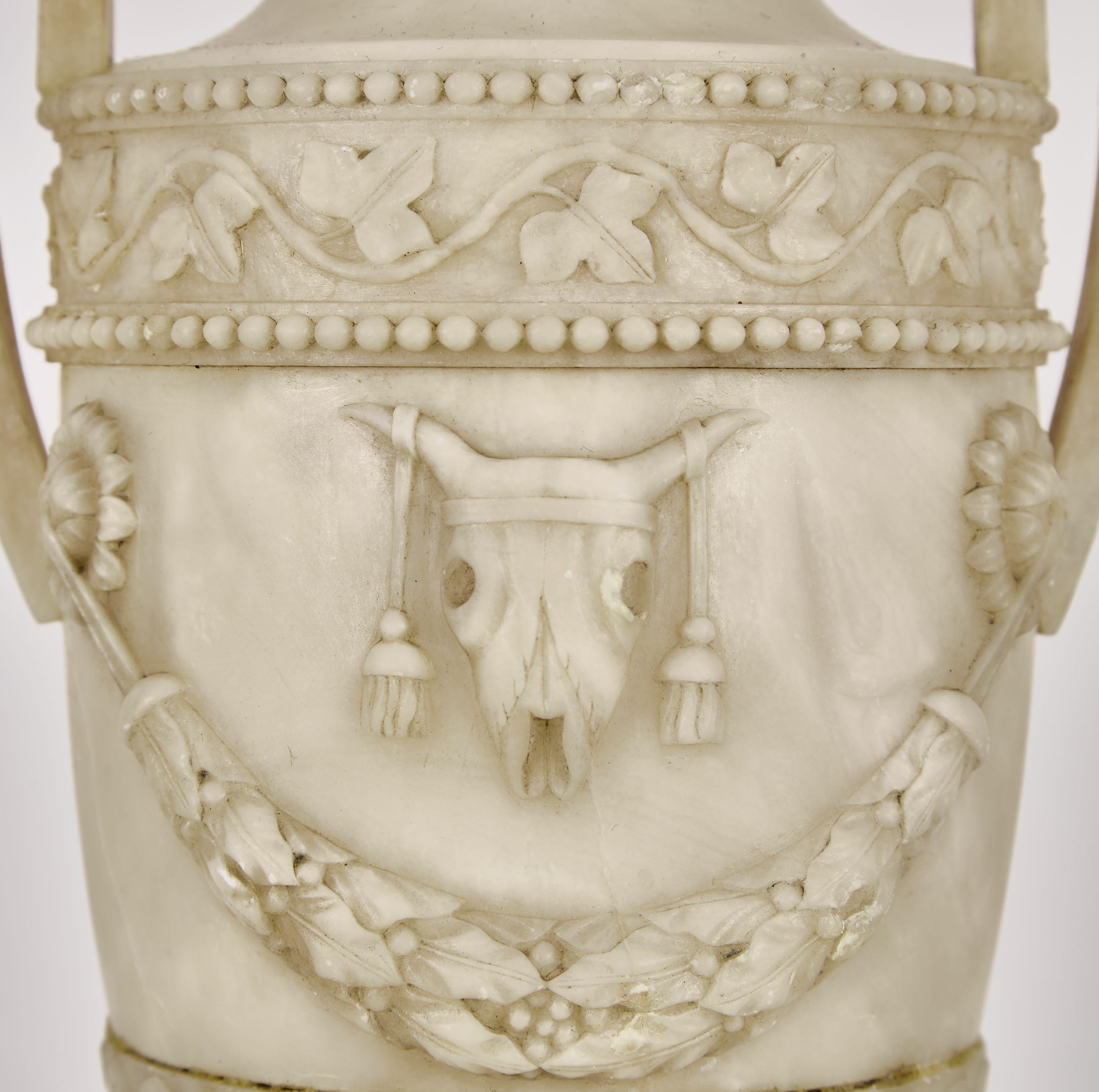 George III Alabaster urn made into a lamp.

Of classical form mounted with scrolling leaf decorated frieze, above a skull and bell petal swag decorated body. Acanthus leaf circular pedestal. Furnished with square lug handles.


Measures: 8