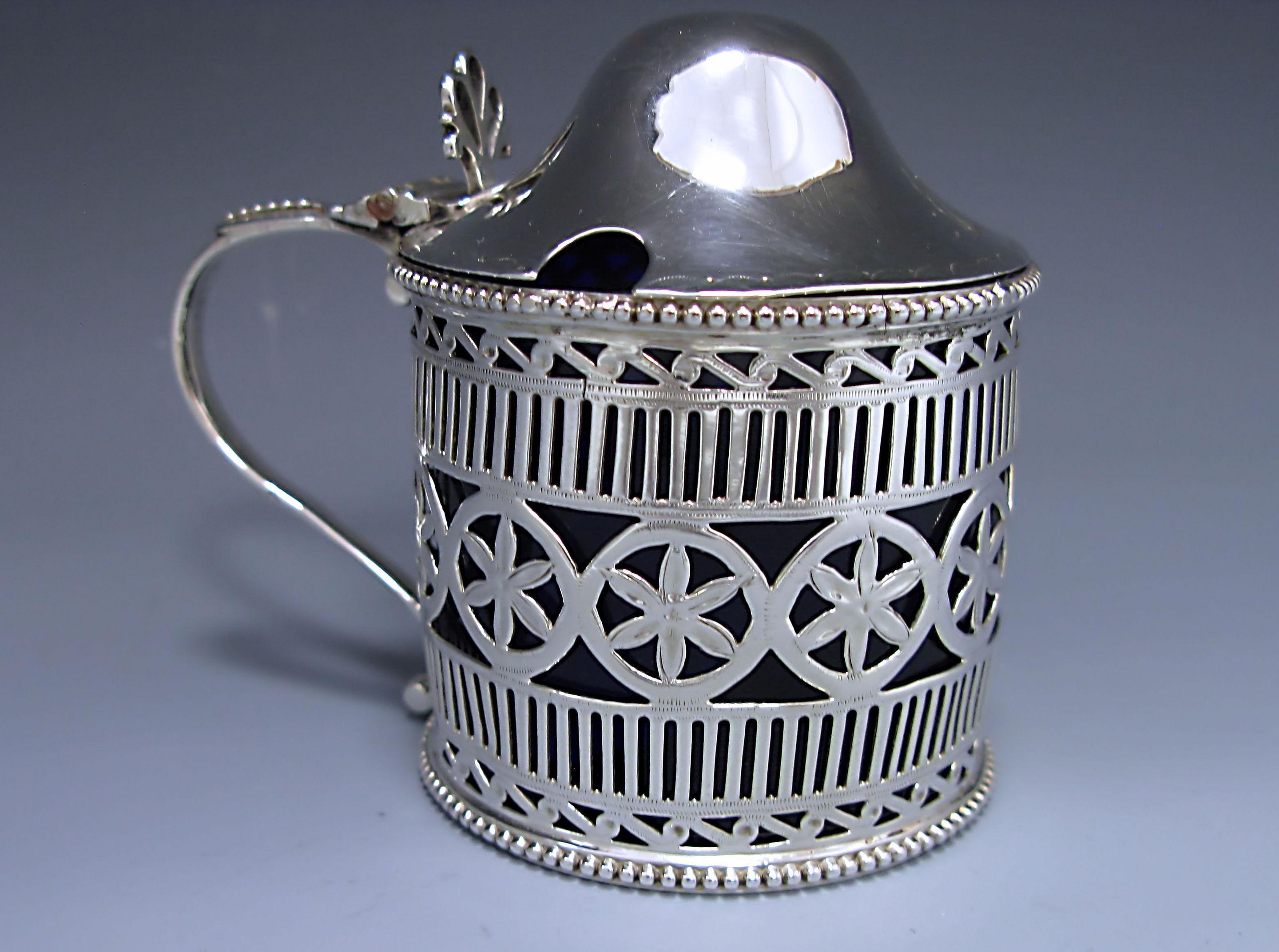 An outstanding George III antique silver drum mustard with a dome lid. The body is embellished with vertical piercing with a central border of stylized flowers. The upper and lower rims of the pot have a bead decorated border. The hinged domed lid