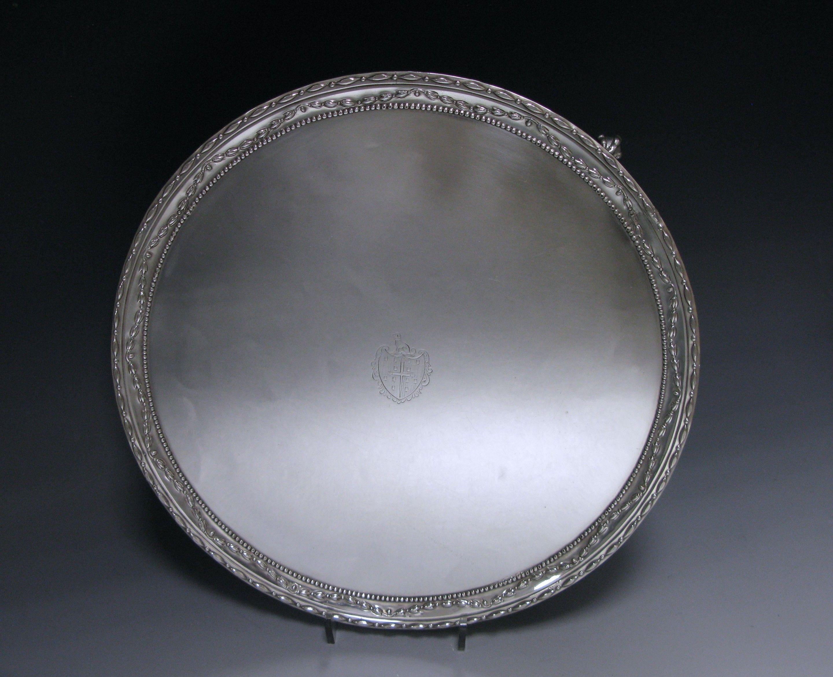 A George III antique silver Salver of circular form, with swag and bead border, the salver stands on three claw and ball feet. The centre is engraved with an armorial of “The arms are those for Norris of Guist and Wood Norton, Norfolk.”.
