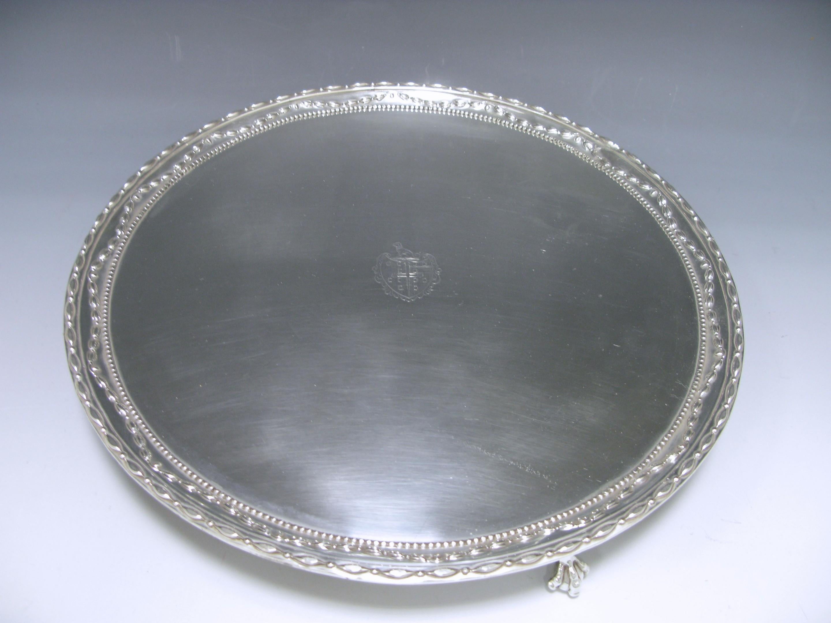 A George III antique silver salver of circular form, with swag and bead border , the salver stands on three claw and ball feet. The centre is engraved with an armorial of “The arms are those for Norris of Guist and Wood Norton, Norfolk.” 
Diameter