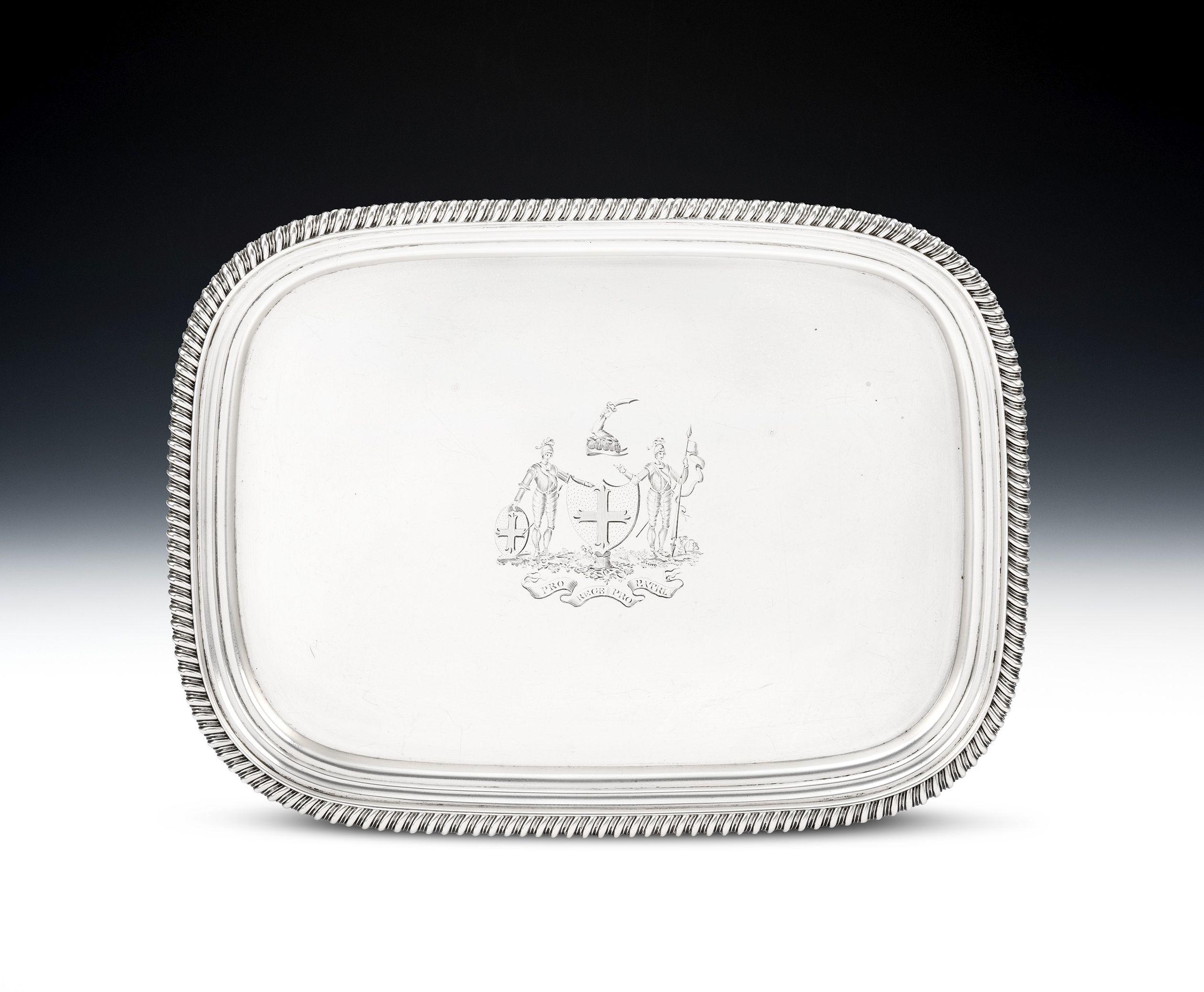 A very fine George III Armorial Salver, of large size. Made in London in 1812 by William Bennett.

The Salver is of a large size and stands on four panel feet with gadrooned borders and scroll ends.  This piece has a stepped rim which is also