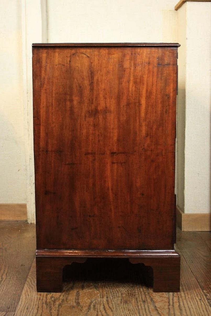 George III figured mahogany chest of drawers with four long drawers and fitted with brush slide in frieze. The cockbeaded drawers are pine lined with cedar sides and having original brass handles and escutcheons.