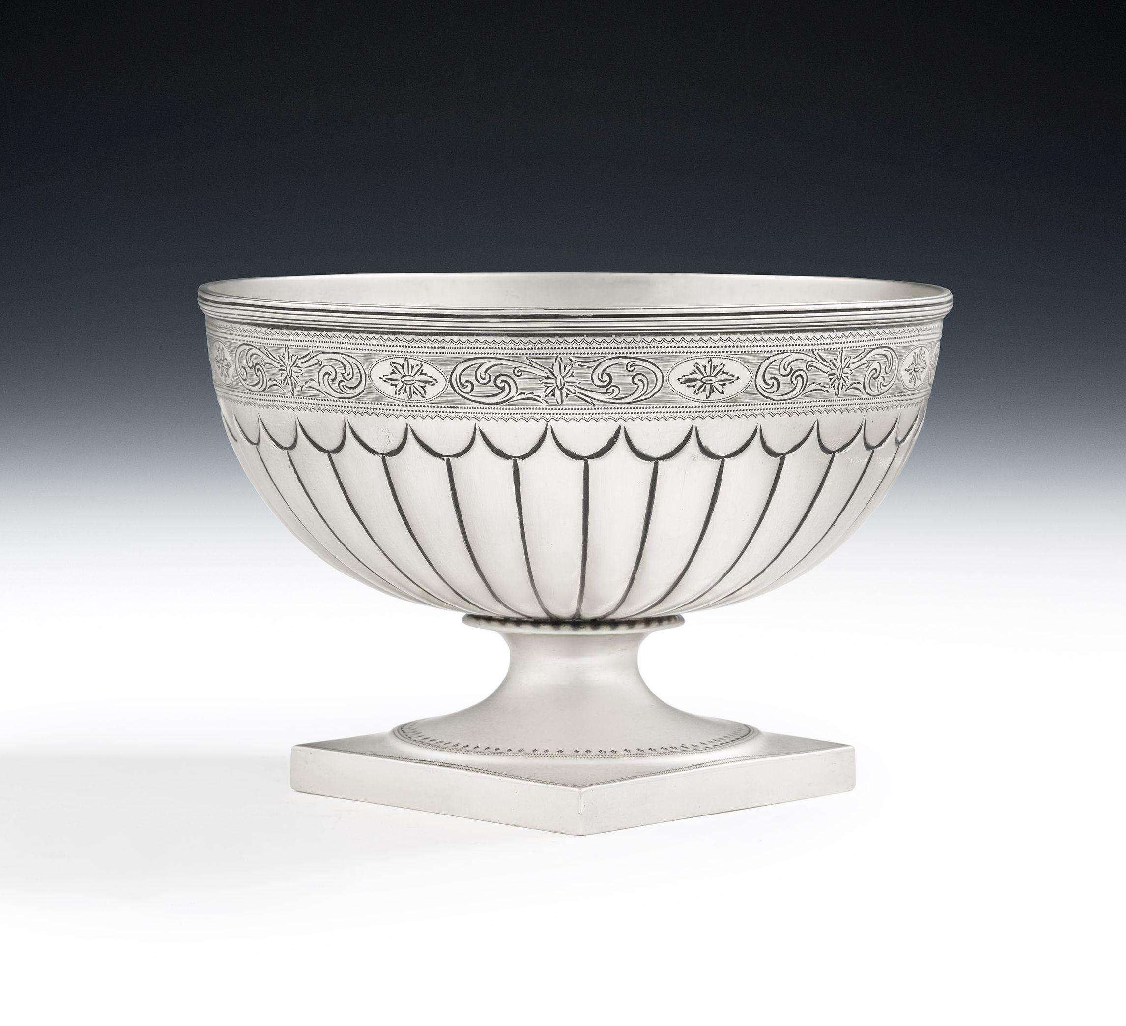 An exceptional George III Bat Wing Fluted Table Bowl made in London in 1790 by Peter Podio.

This beautiful piece stands on a square pedestal foot decorated with a bright cut band.  The main body displays a lower, wide, band of bat wing fluting and