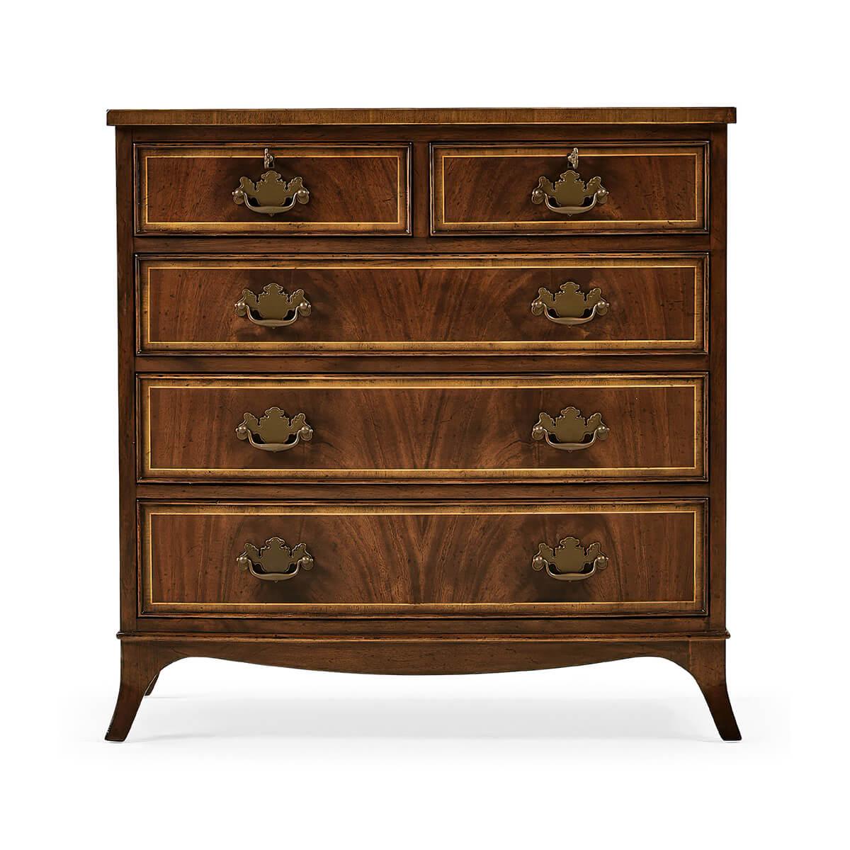 Piccola cassettiera in stile classico georgiano in mogano e a fasce incrociate, ideale come scendiletto, con legni secondari in Oak, con leggero effetto anticato sui due cassetti corti e sui tre cassetti lunghi graduati. Il tutto poggia su gambe