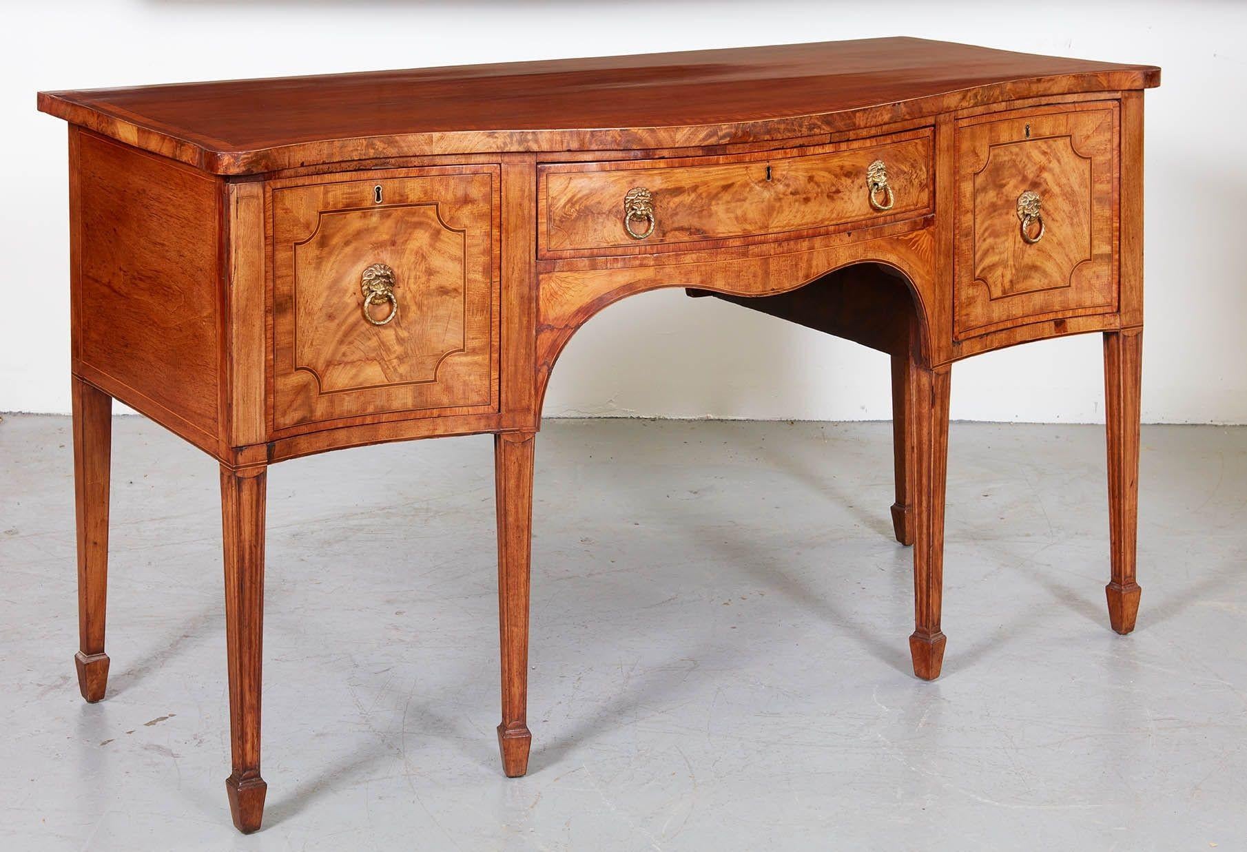 A fine period George III bowfront Hepplewhite mahogany sideboard. An imposing piece, featuring marquetry inlaid sunray corners, featherbanded drawer fronts with curved satinwood string inlay, finely cast brass lion-head ring pulls and vividly