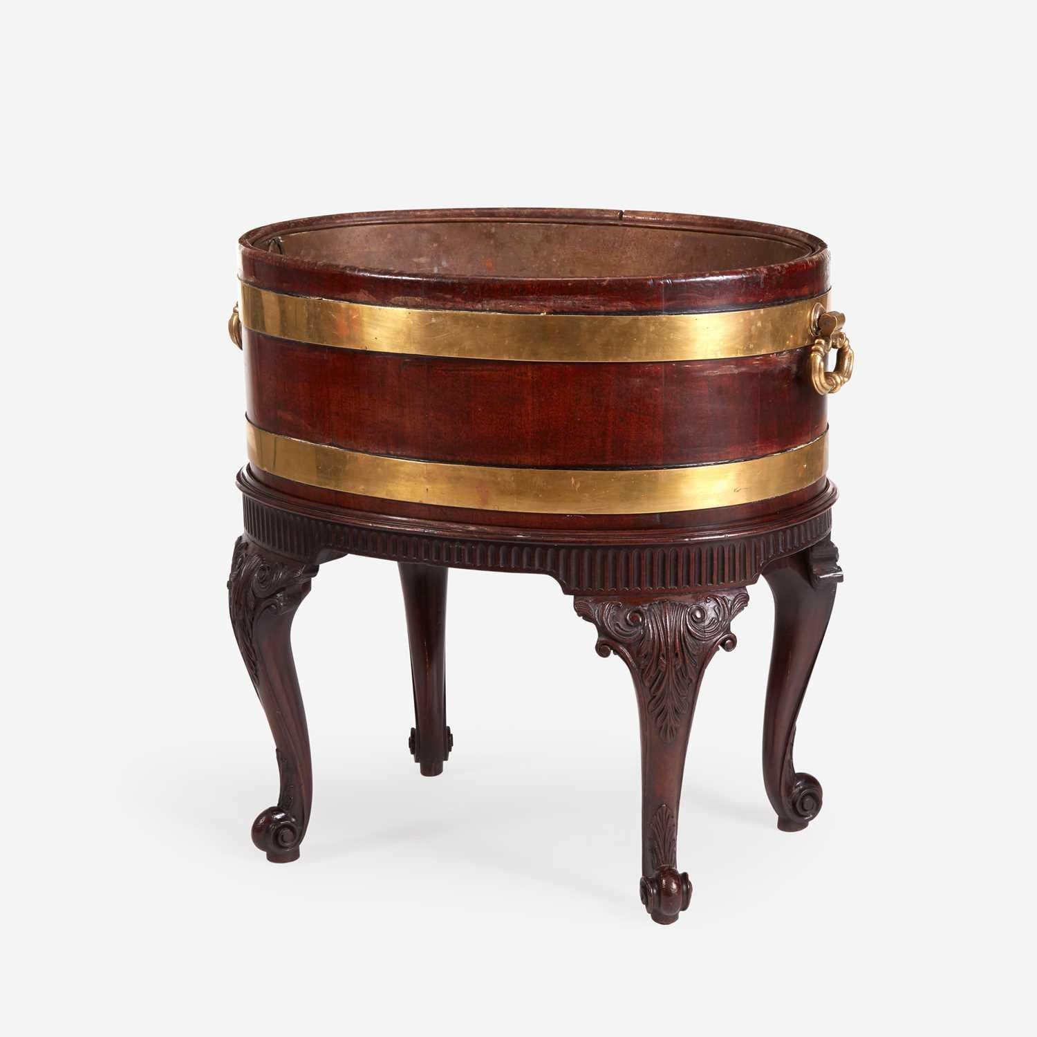 Flowers or Champagne? Or Both?

George III Brass Bound Mahogany Wine Cooler or Cellaret,
Third-quarter of 18th century

The George III brass-bound mahogany wine cooler or cellaret (also known as a cellarette) is of oval form, with two brass