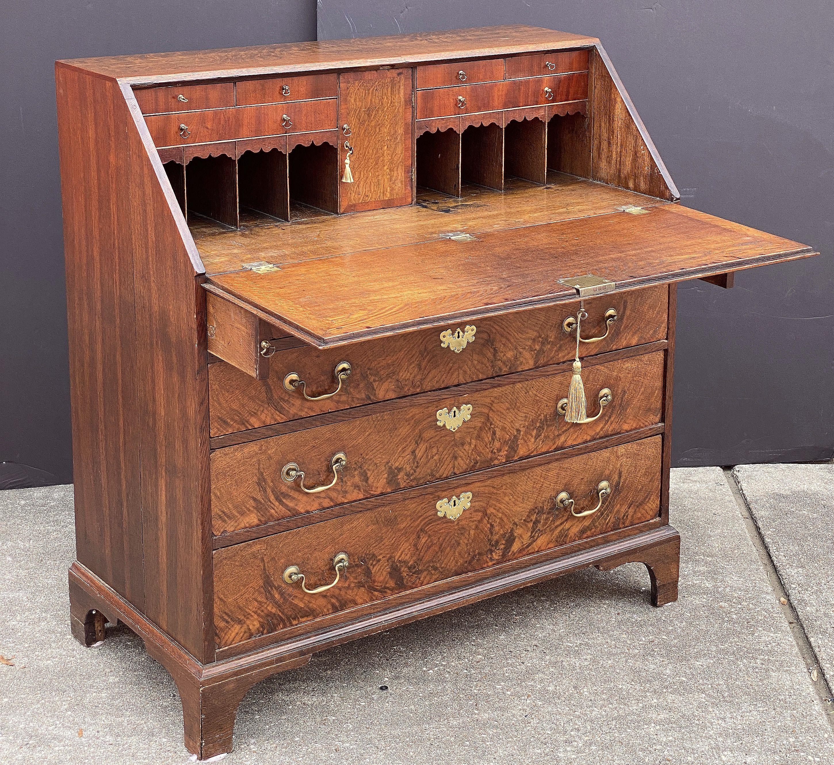 A fine George III slant top desk or bureau secretary chest of elm, oak and padouk woods, c.1780 - an inlaid slant front drops to reveal a series of small drawers and document compartments, over a frieze of four graduated long drawers, the drawers