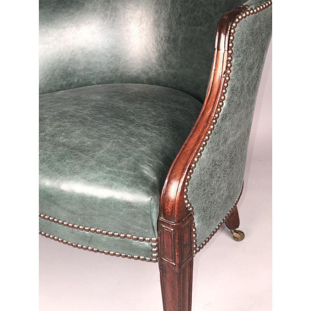 A late 18th century carved mahogany library tub chair, with a moulded show-wood frame of good rich color and patination, in close-nailed green hide.
George III period, circa 1770-1780. 

This antique English chair is a particularly fine,