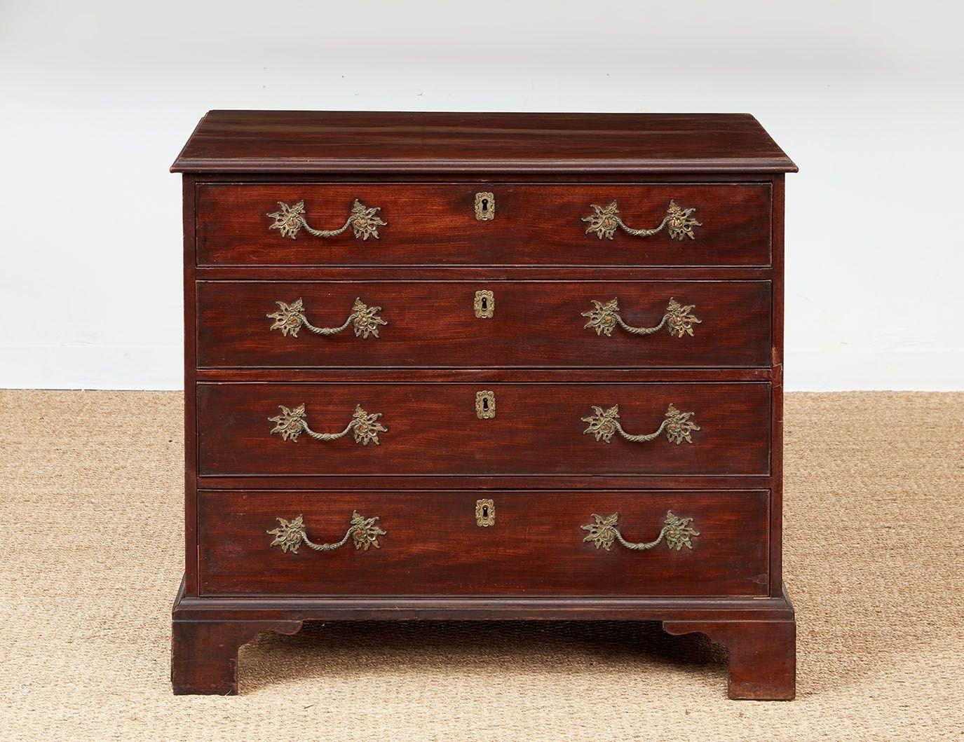 A George III chest of drawers with ogee molded top over four cock-beaded graduated drawers with later rococo pulls, standing on a Chippendale bracket base.  Rich and vividly grained mahogany.  English, circa 1770.