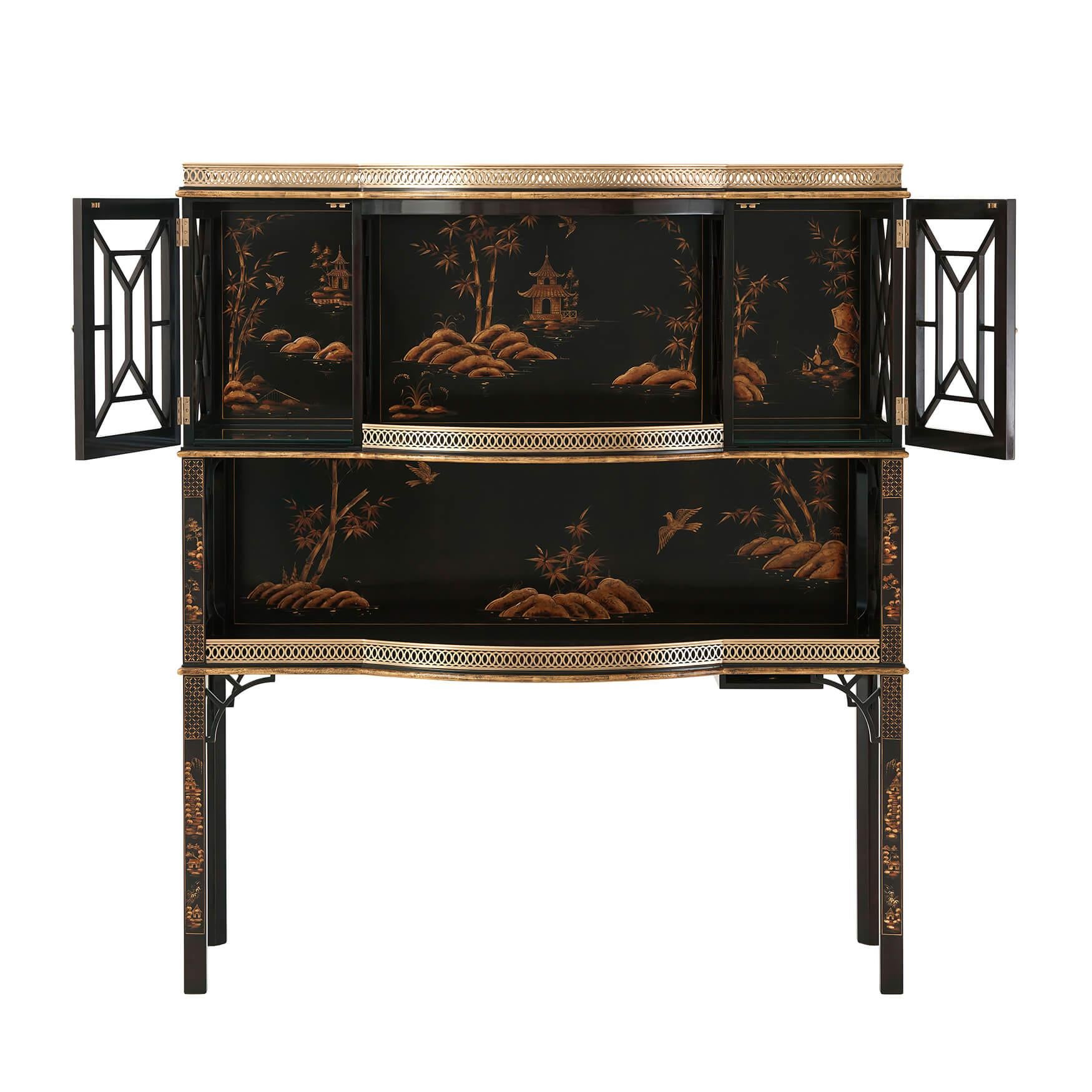 An English chinoiserie bar or display cabinet, the break bowfront brass gallery top above a delicately Chocolate chinoiserie hand-painted interior of two galleried shelves with pierced cabinet doors enclosing lights on square chamfered legs with