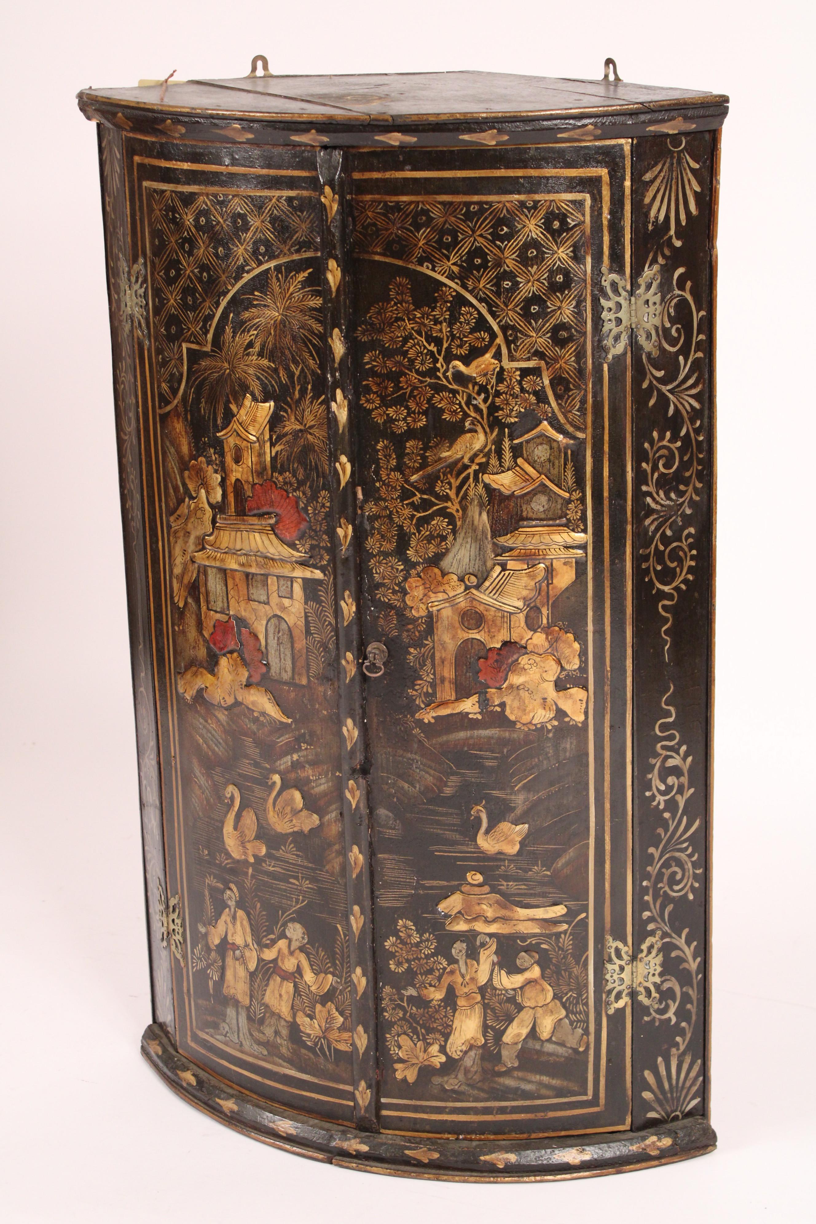 George III chinoiserie decorated hanging corner cabinet, late 18th century. The two doors decorated with Chinese figures, tea houses, swans and birds. The chinoiserie decoration is raised, not flat.