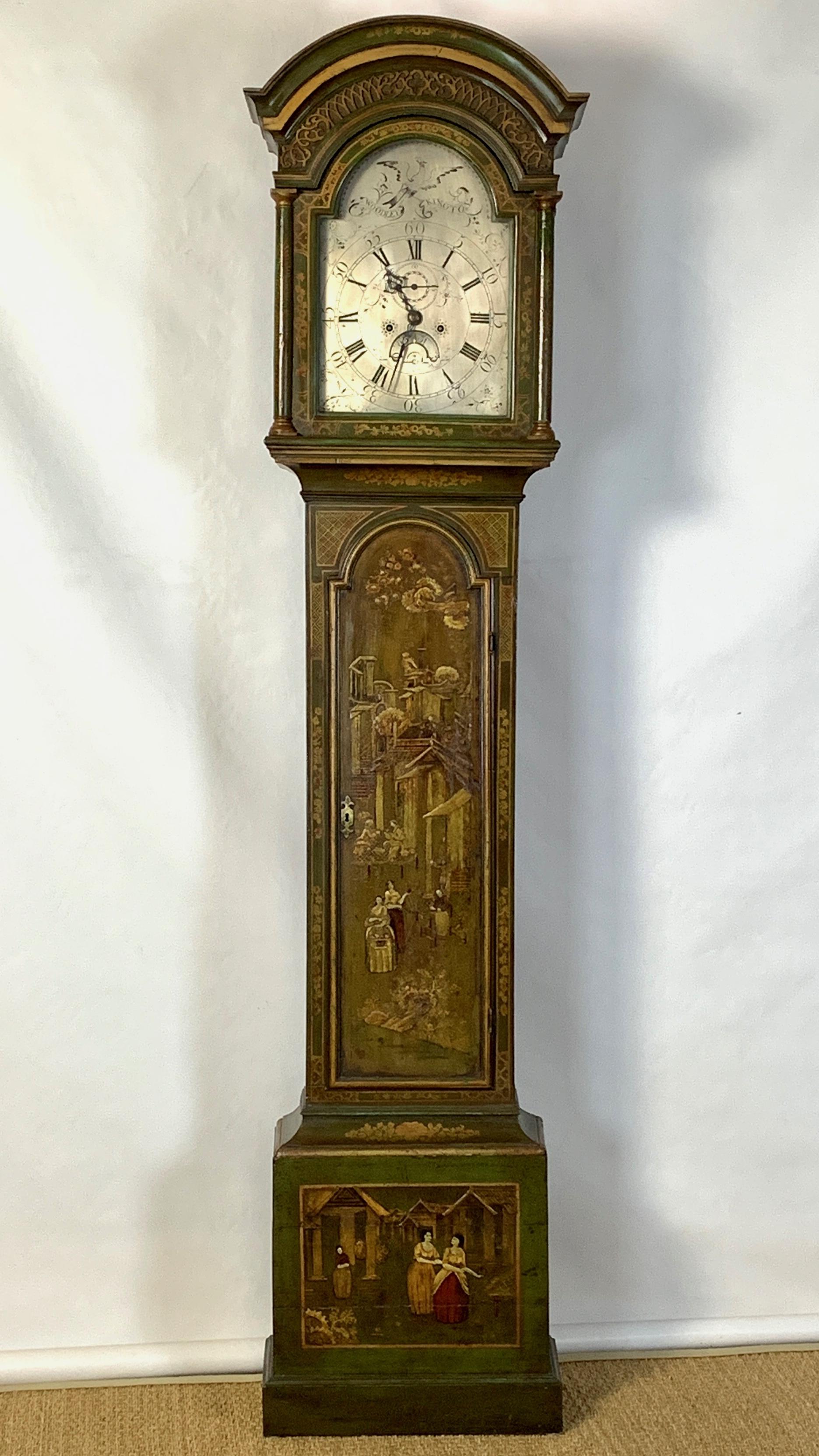 A late 18th century English 8-day tall case clock by Woodley, Kington. The elegant green painted chinoiserie decorated case displays figures in a fanciful landscape. The graceful domed bonnet holds a silvered face with complications including second