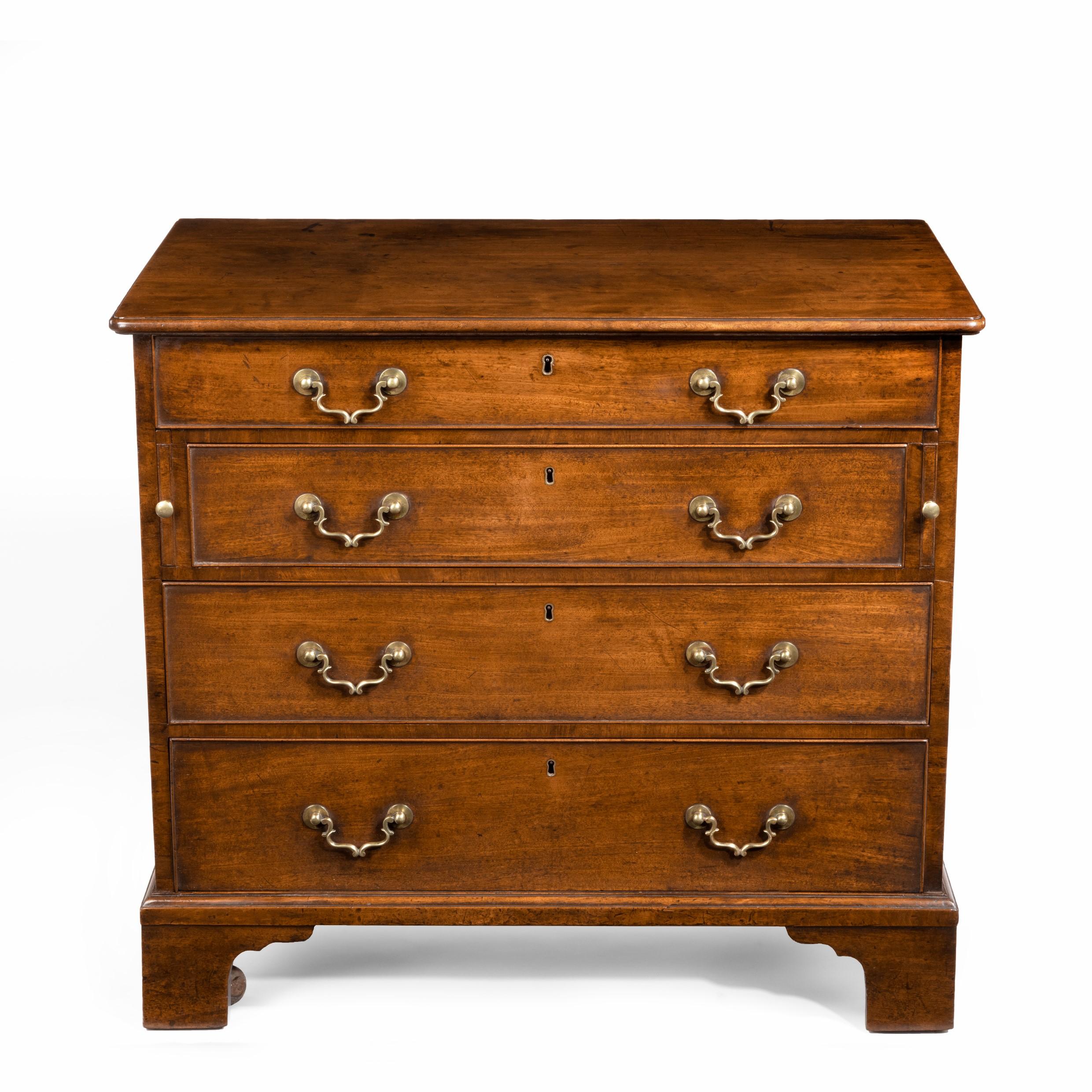 A George III, Chippendale period, mahogany chest of drawers, of rectangular form with four graduated drawers with the original bracket handles, the top drawer fitted with a brushing slide, three compartments and a hinged pen-tray, all on square