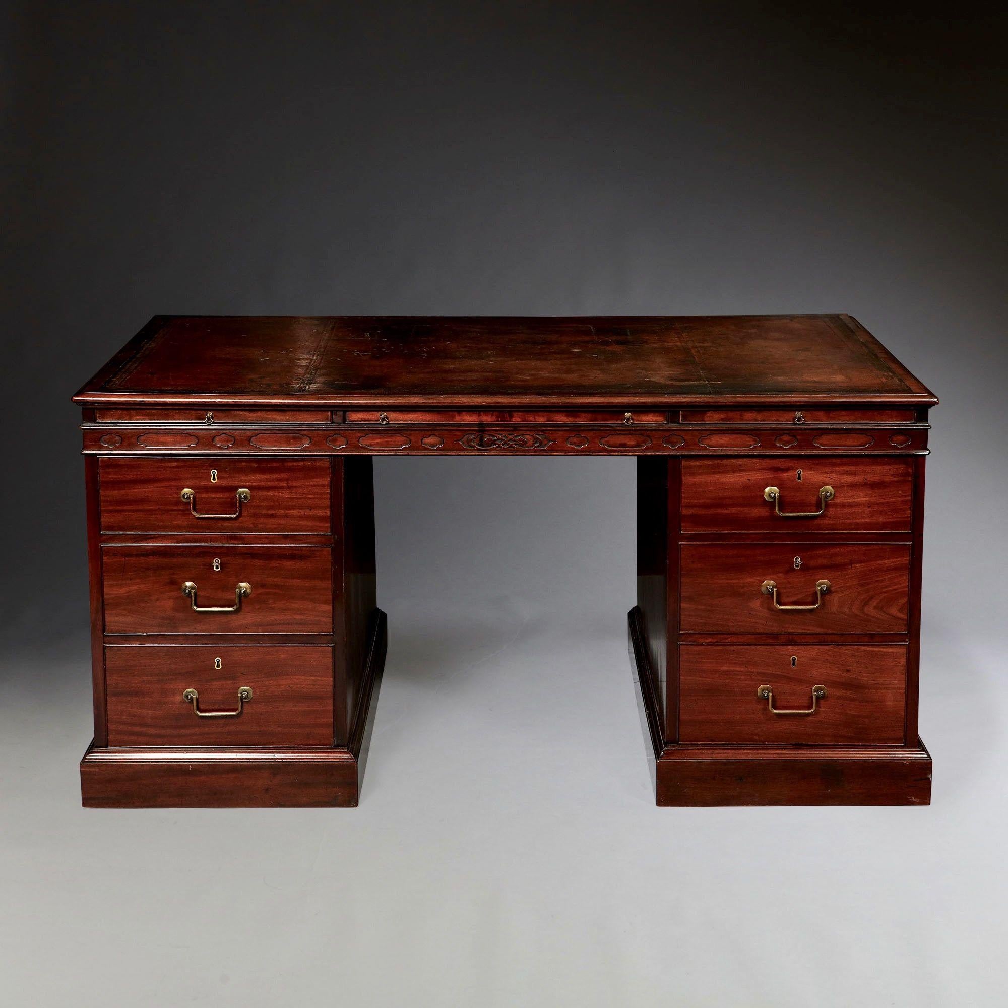 George III 18th Century mahogany partners desk concealing twenty-four small drawers. In the manner of Thomas Chippendale. 

The original sectioned and tooled leather top sits above two short and three long quill/pen drawers to each side neatly