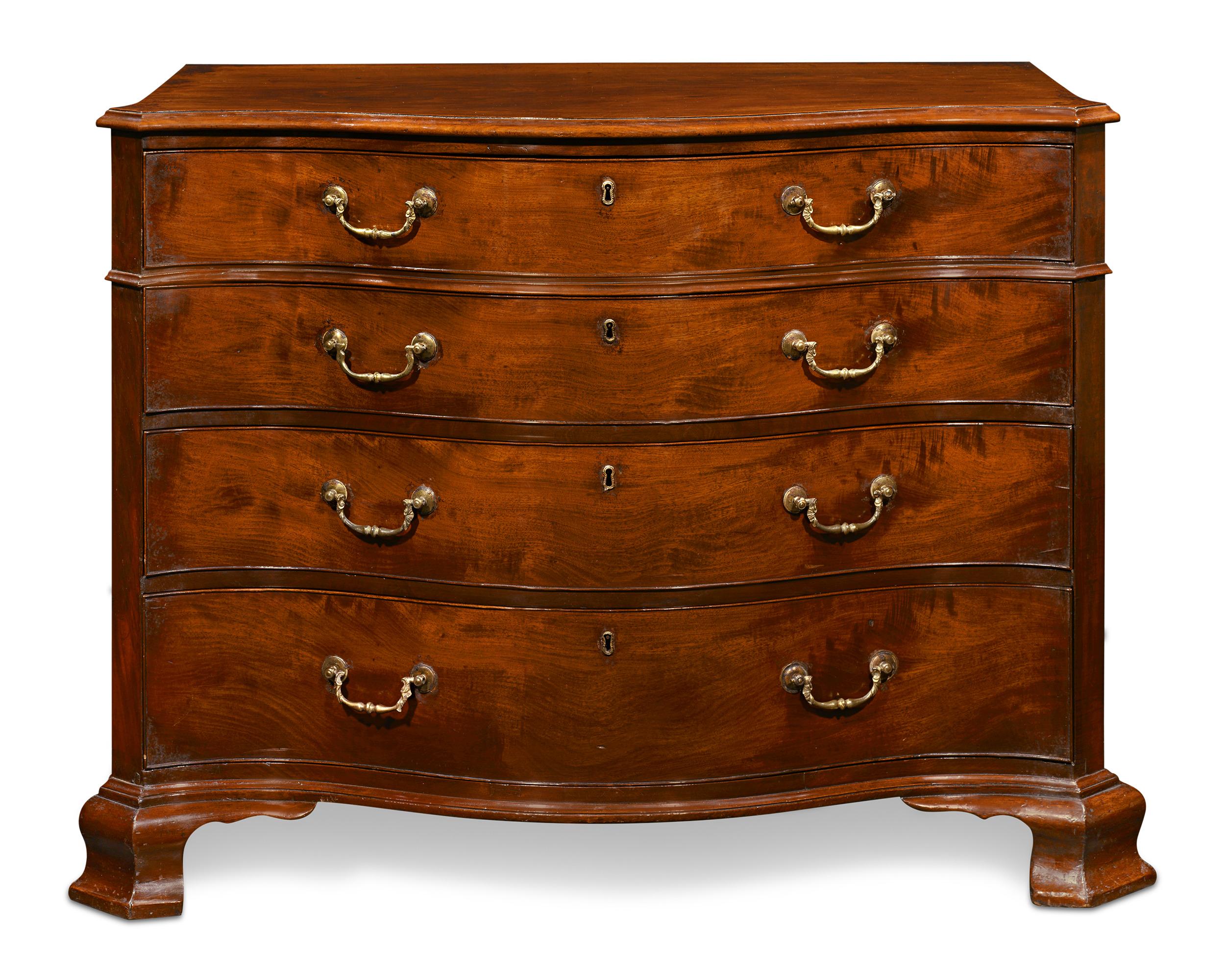This rare 18th-century serpentine chest of drawers was crafted in the style of the iconic Thomas Chippendale. The George III mahogany dresser is complete with its original brass handles and features four graduated, lockable drawers with keyholes