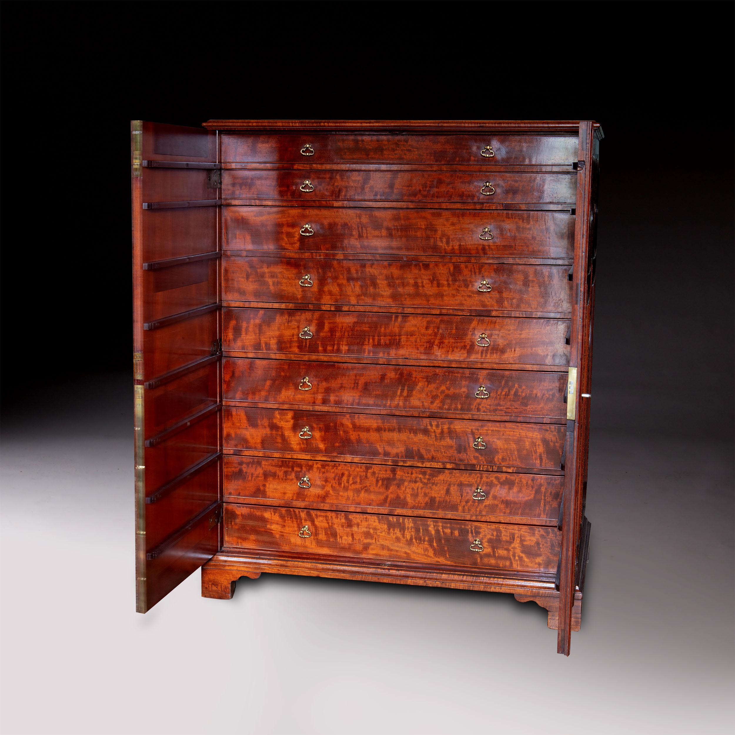 A magnificent late 18th-century flame mahogany collectors cabinet, the sides and doors inset with the most fabulous flame mahogany within raised borders of 'woven' boxwood and ebony, opening to nine long drawers with rich flame mahogany veneers and