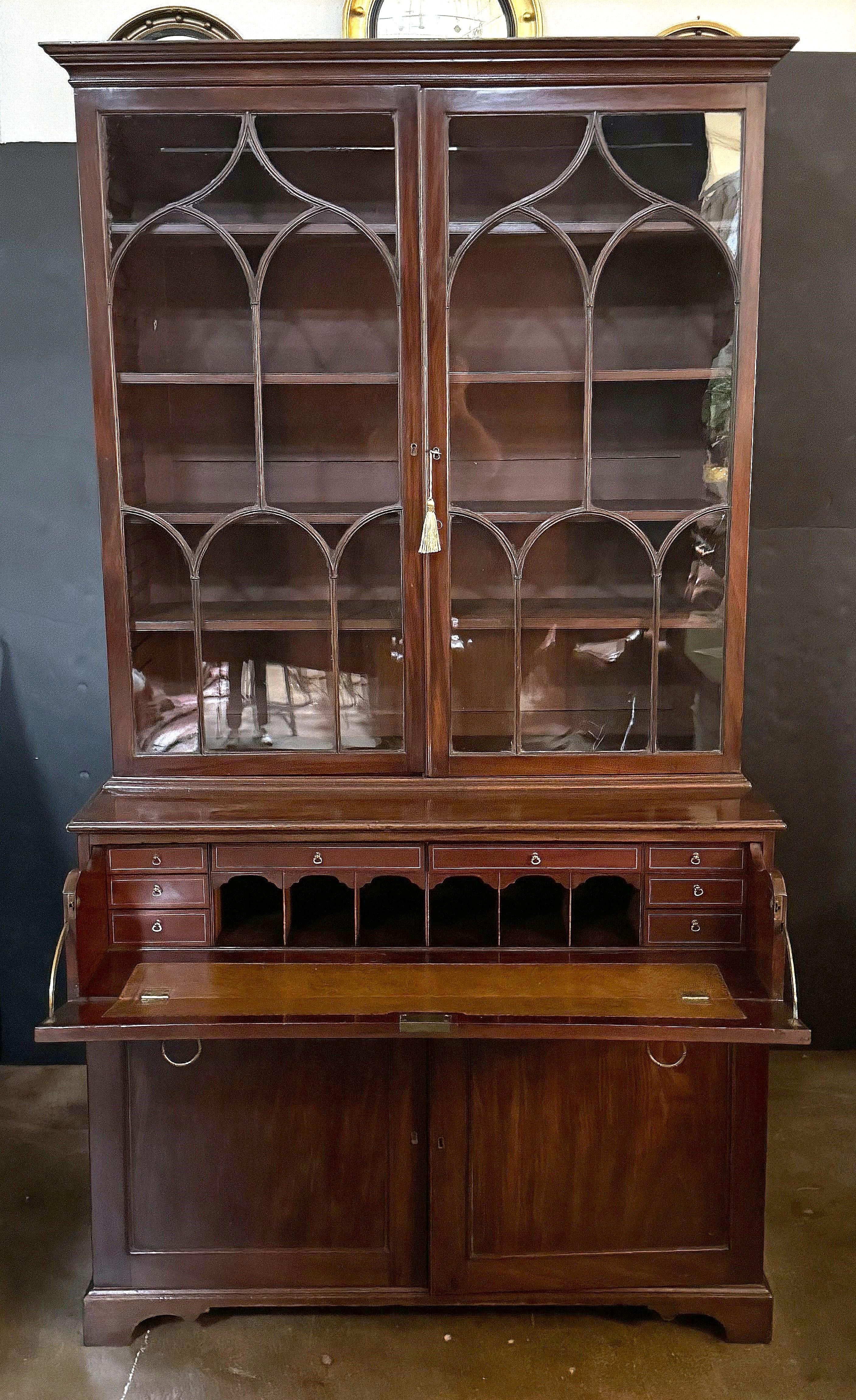 A fine English double secretary bookcase of mahogany from the late Georgian era, c.1780, featuring a crown moulded top with two astragal glazed doors, each side opening to four long adjustable shelves.

Set upon a bottom tier with a faux drawer fall