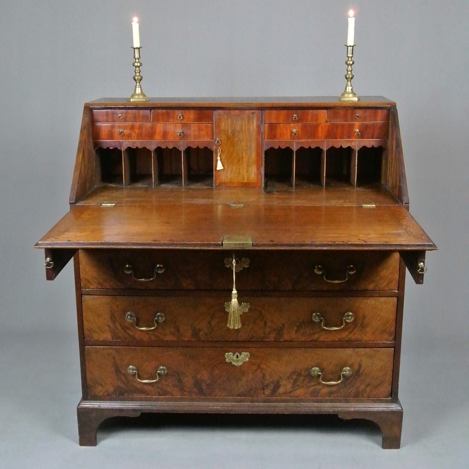A very good and rarely seen figured elm bureau with a fine interior of padouk faced drawers with brass drop handles and an oak central door, crossbanded in padauk, with original lock and working key and opening to reveal a secret padauk fronted