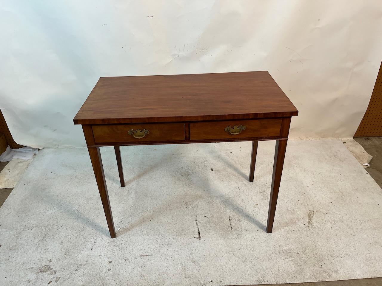 George III end table with two drawers.  The top has a gorgeous patina that is echoed in the two drawers.  Tapered legs and original brasses.  Mahogany, pine secondary wood, brass hardware.
