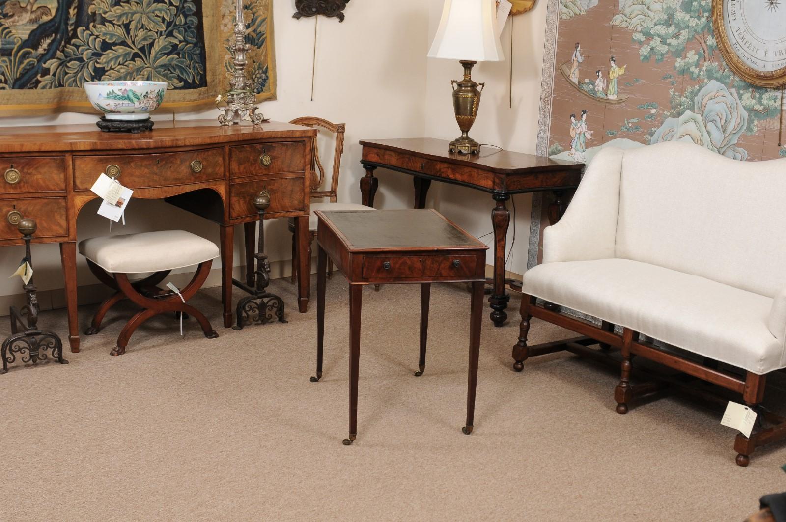 The late 18th century George III English mahogany side table with rectangular black leather and adjustable top, drawer below and tapered legs ending in brass castors. 

 