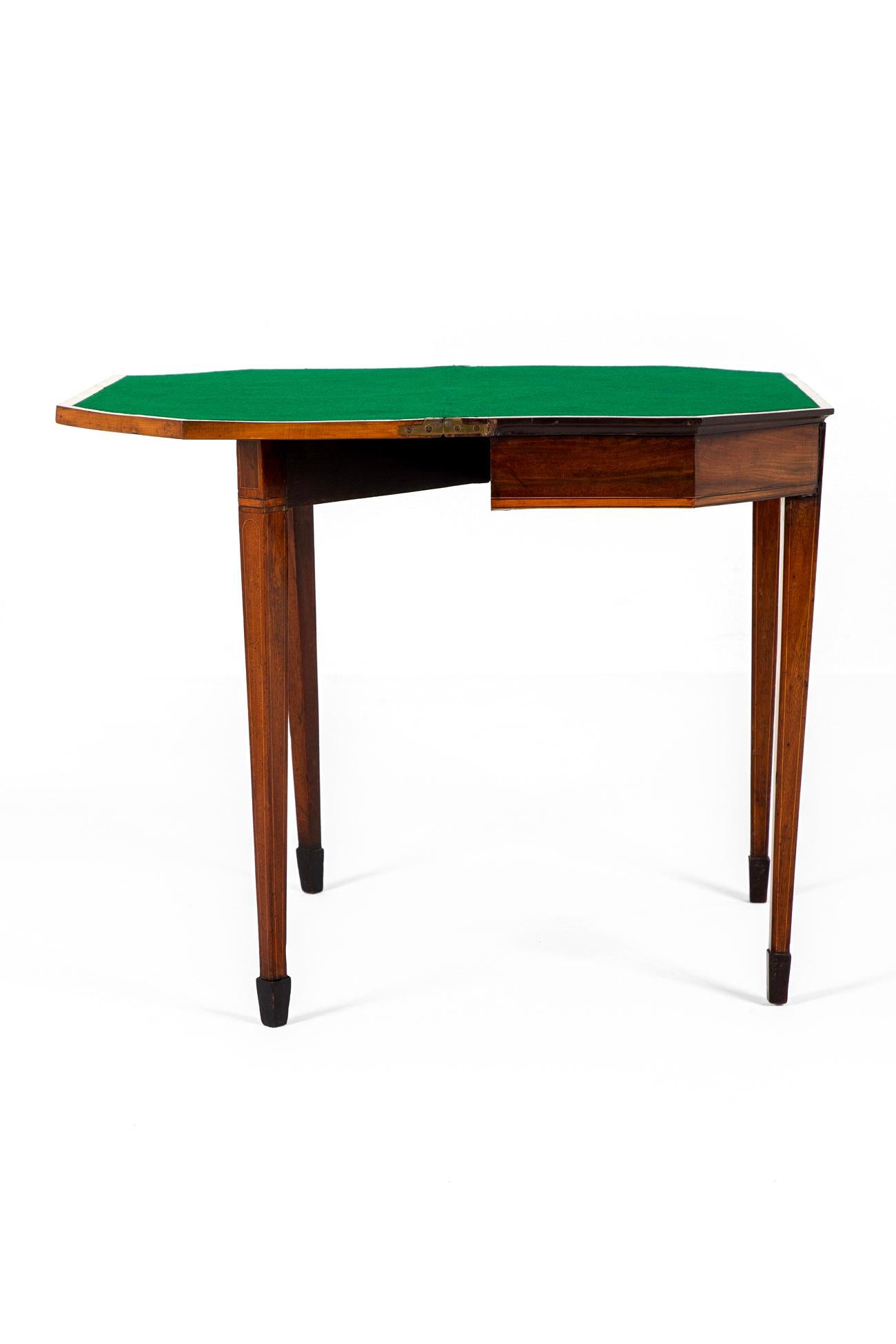 A grand George III mahogany card table with satinwood banding throughout.

The hinged top opens and effortlessly swings into place enclosing a forest green baize lined top playing surface in good condition.

Beneath the table top two supports fold