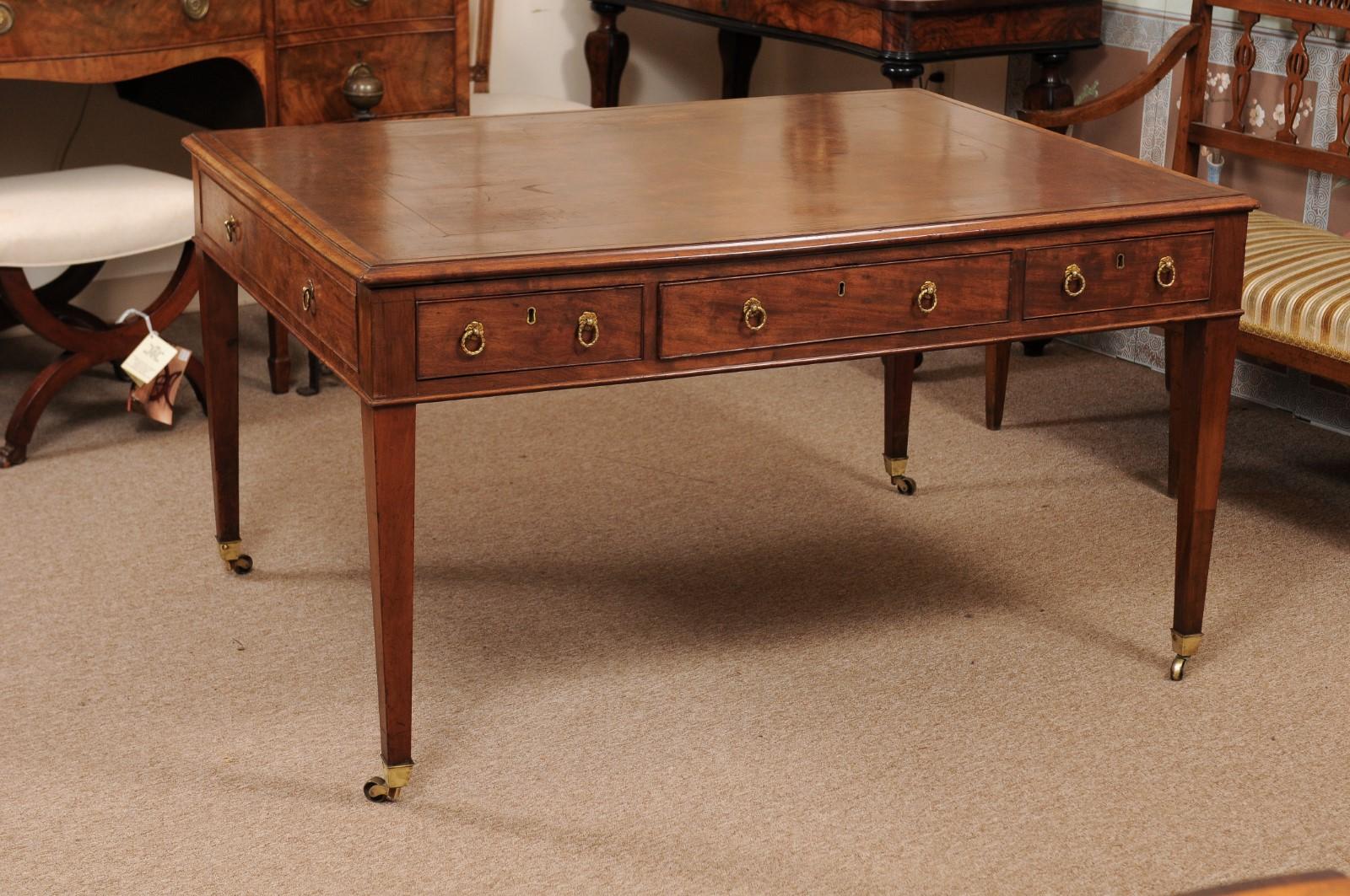 The George III English mahogany partner's desk featuring brown leather top, 6 drawers with brass pulls terminating in tapered legs with brass castor feet.



 