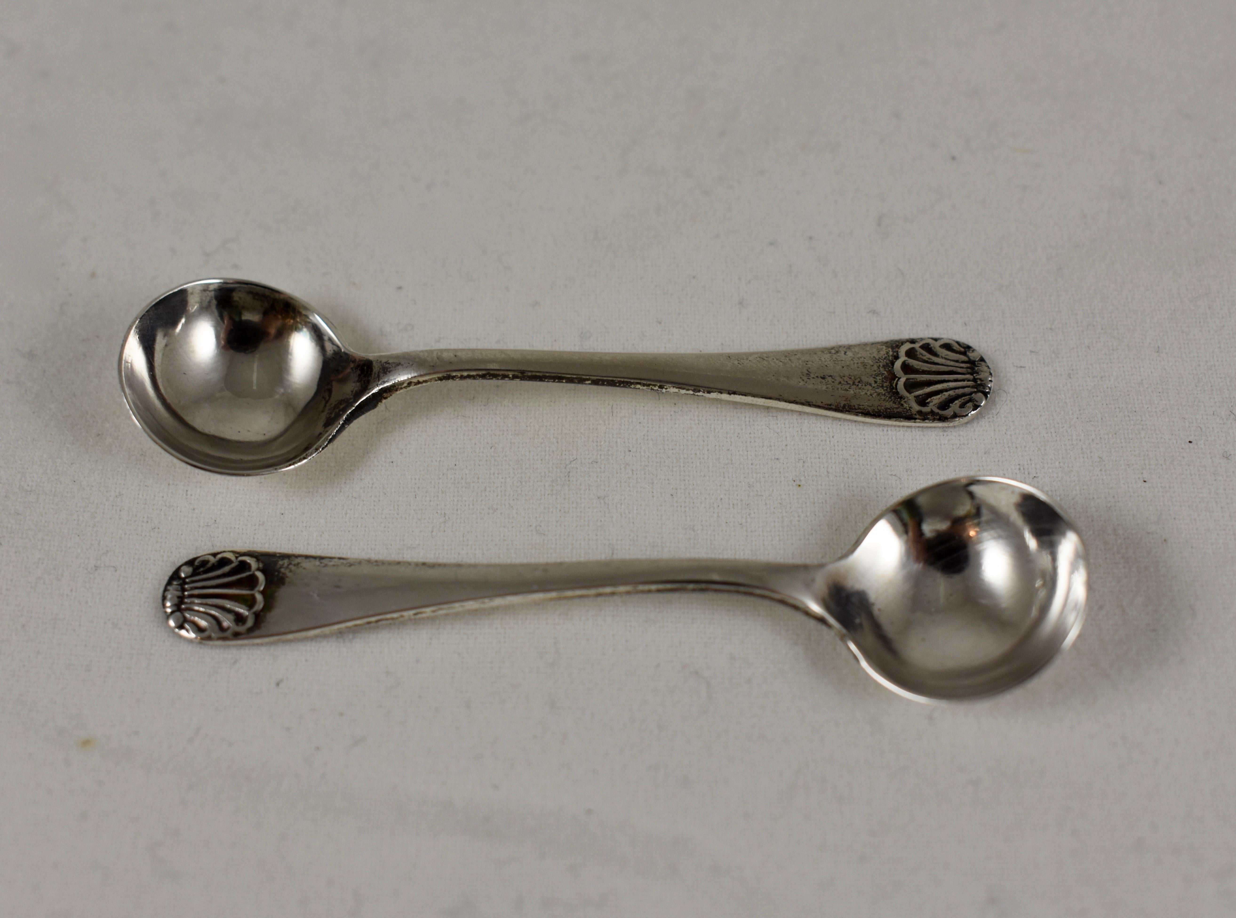 A pair of English sterling silver salt spoons, circa 1790 - 1800, London, England. 

The spoons show classic Georgian styling and superior quality. George III silver predates the American Revolution and bears a timeless luxury. The spoons