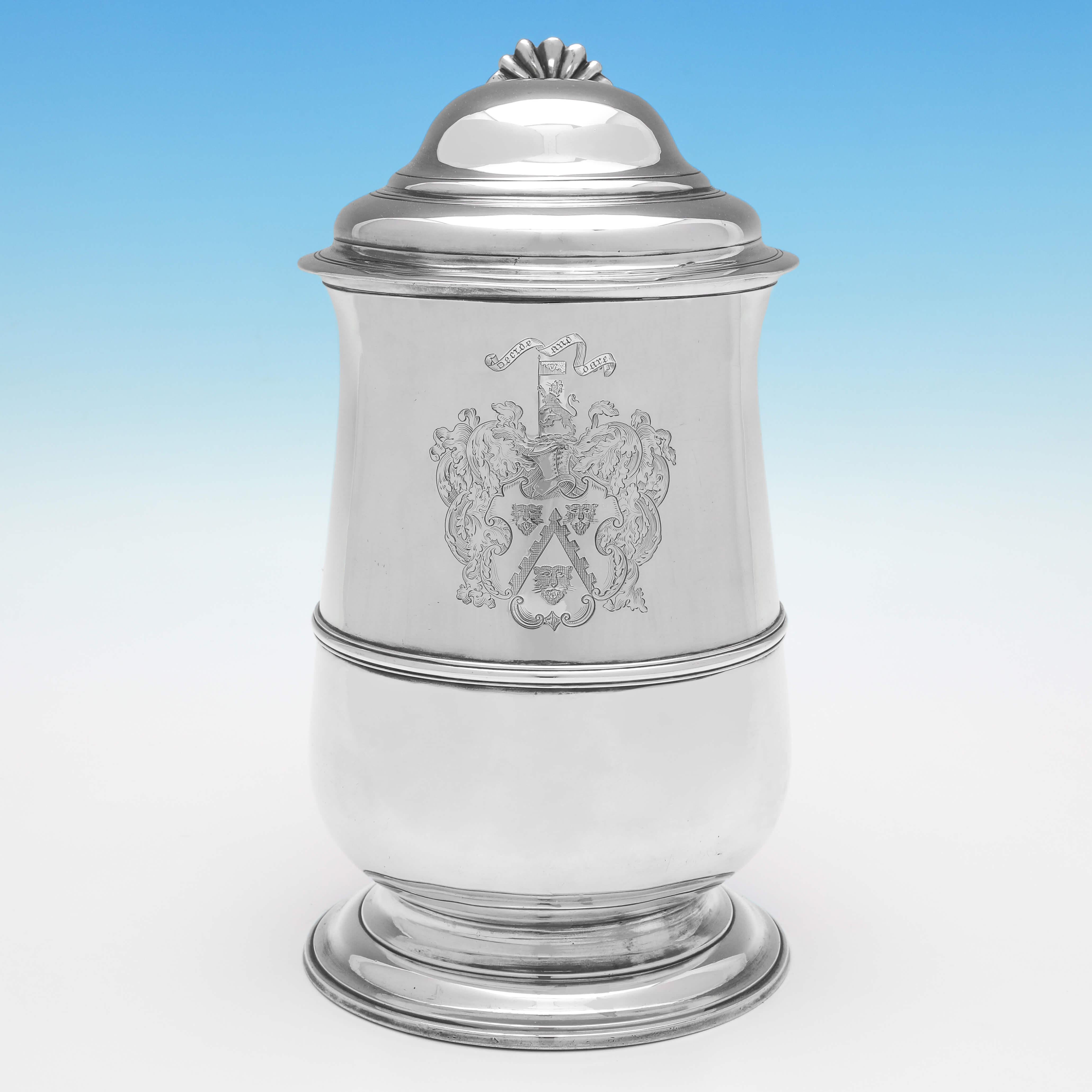 Hallmarked in London in 1772 by William Plummer, this handsome, George III, Antique Sterling Silver Tankard, is baluster shaped, and features reed detailing, a domed lid, and an engraved coat of arms opposite the handle. 

The tankard measures