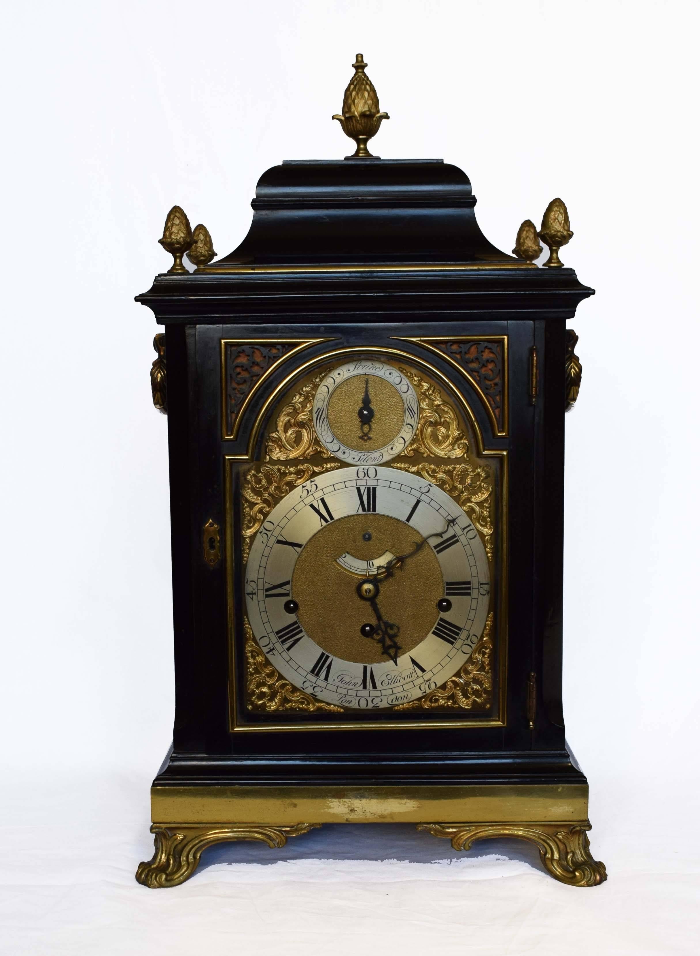 A fine and rare George III gilt brass-mounted ebonized quarter chiming bracket clock by John Ellicott (London, 1706-1772)

The bell top inset with five pineapple finials, over shaped glazed side apertures to a moulded base set with brass band and